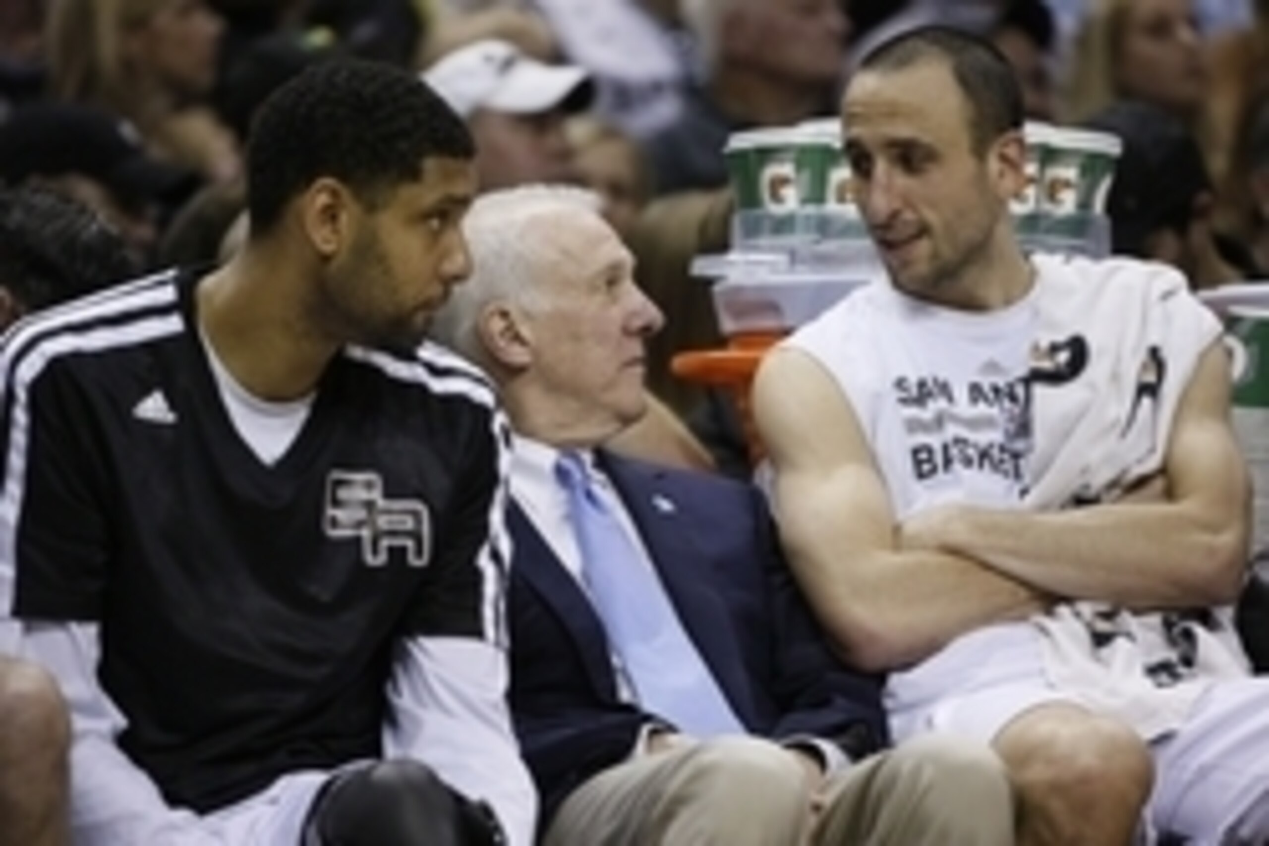 Apr 2, 2014; San Antonio, TX, USA; San Antonio Spurs guard Manu Ginobili (right), and head coach Gregg Popovich (center), and Tim Duncan (left) talk on the bench during the second half against the Golden State Warriors at AT&T Center. The Spurs won 111-90