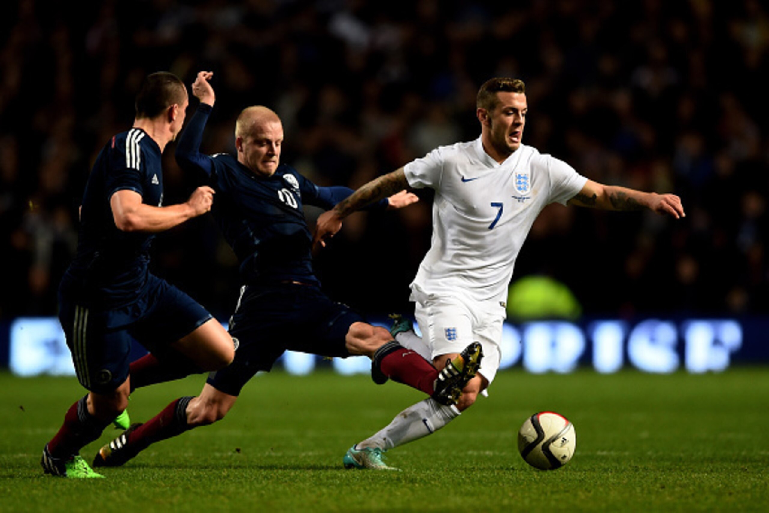 GLASGOW, SCOTLAND - NOVEMBER 18:  Jack Wilshere of England is challenged by Steven Naismith of Scotland and Scott Brown of Scotland during the International Friendly match between Scotland and England at Celtic Park Stadium on November 18, 2014 in Glasgow