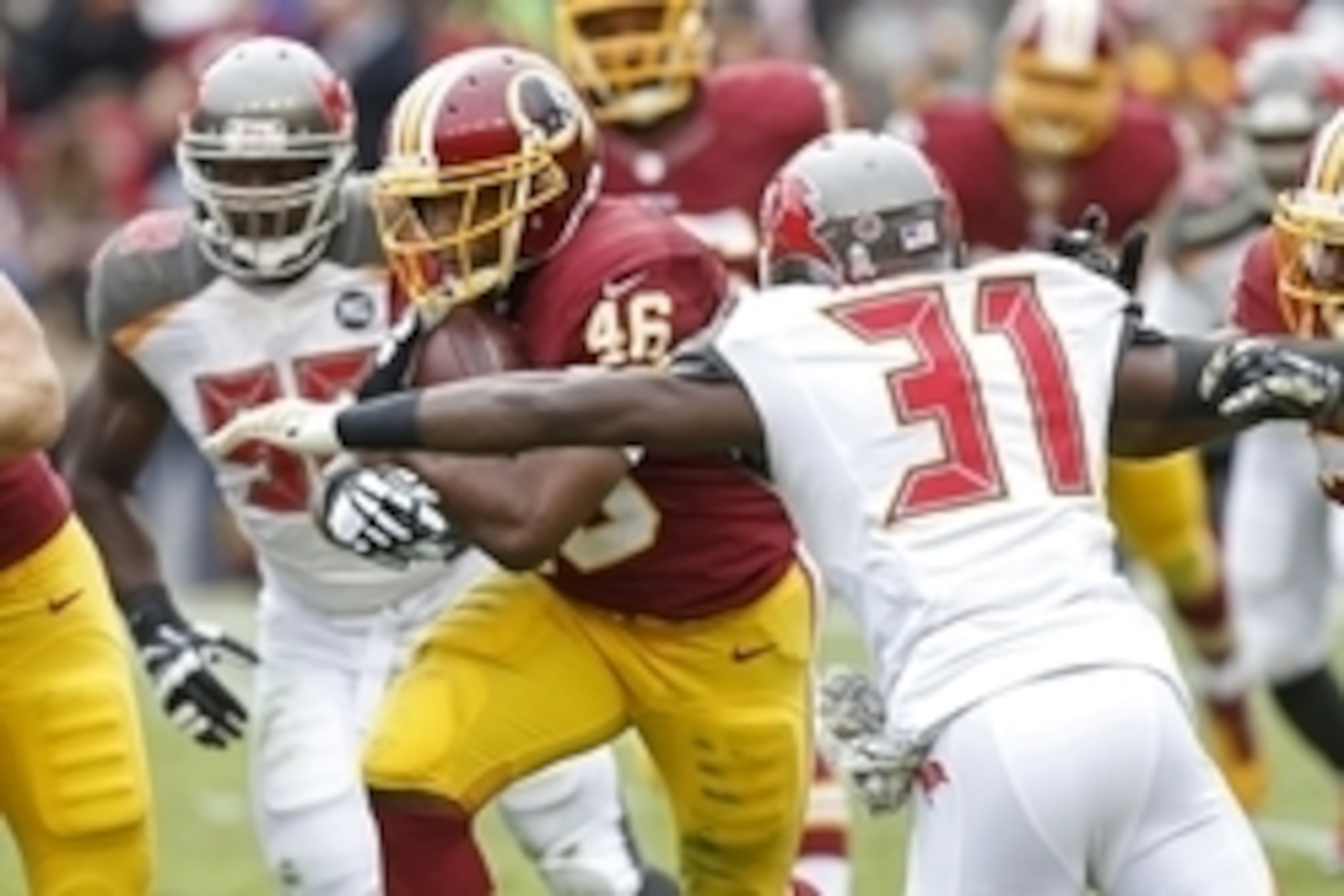 Nov 16, 2014; Landover, MD, USA; Washington Redskins running back Alfred Morris (46) carries the ball as Tampa Bay Buccaneers free safety Major Wright (31) attempts the tackle in the second quarter at FedEx Field. Mandatory Credit: Geoff Burke-USA TODAY S