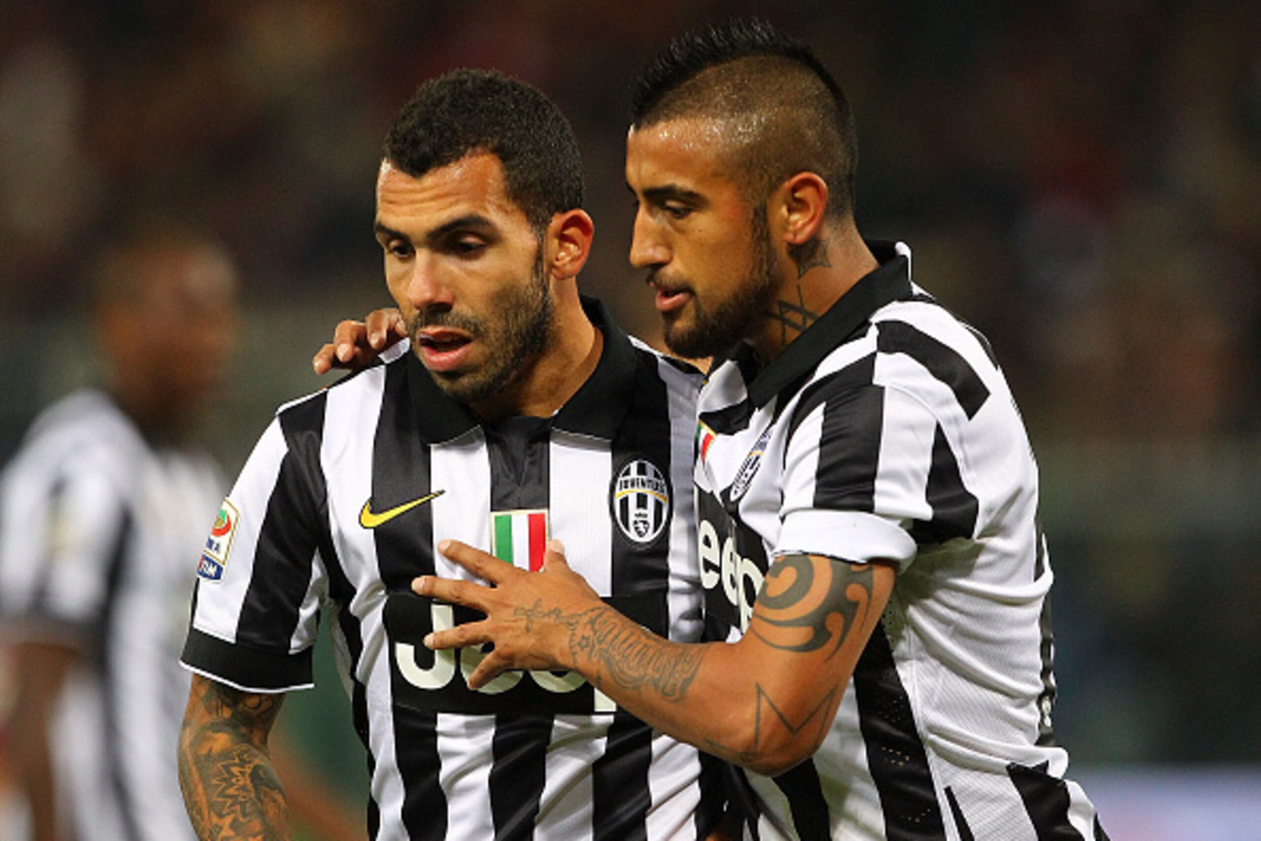 GENOA, ITALY - OCTOBER 29:  Arturo Vidal (R) of Juventus FC speaks to his team-mates Carlos Tevez (L)  during the Serie A match between Genoa CFC and Juventus FC at Stadio Luigi Ferraris on October 29, 2014 in Genoa, Italy.  (Photo by Marco Luzzani/Getty 