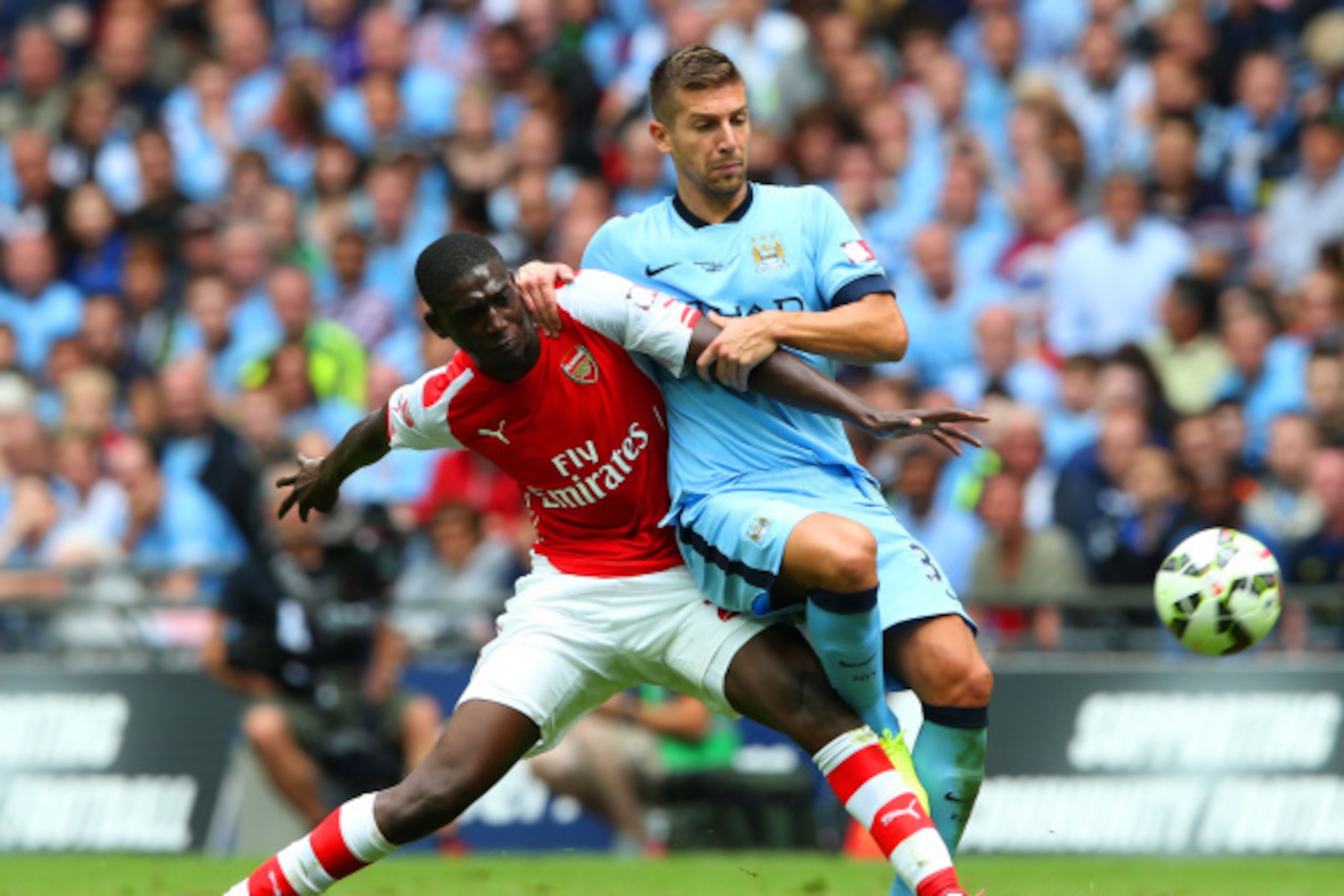 LONDON, ENGLAND - AUGUST 10: Yaya Sanogo of Arsenal challenges Matija Nastasic of Manchester City during the FA Community Shield match between Manchester City and Arsenal at Wembley Stadium on August 10, 2014 in London, England.  (Photo by David Rogers/Ge