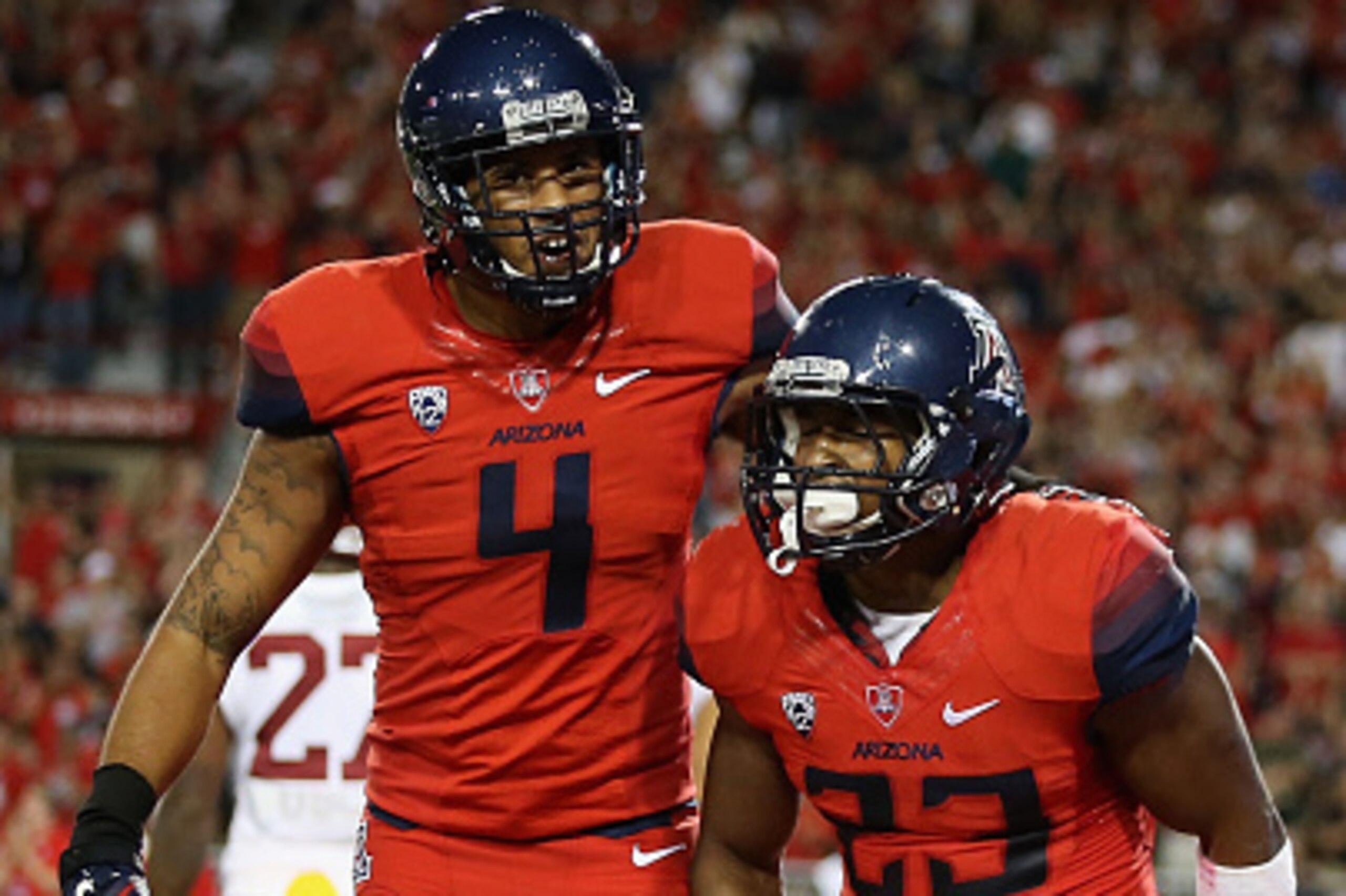 TUCSON, AZ - OCTOBER 11: Running back Jared Baker #23 of the Arizona Wildcats is congratulated by wide receiver David Richards #4 after scoring a 41 yard touchdown reception against the USC Trojans during the fourth quarter college football game at Arizo TUCSON, AZ - OCTOBER 11: Running back Jared Baker #23 of the Arizona Wildcats is congratulated by wide receiver David Richards #4 after scoring a 41 yard touchdown reception against the USC Trojans during the fourth quarter college football game at Arizo