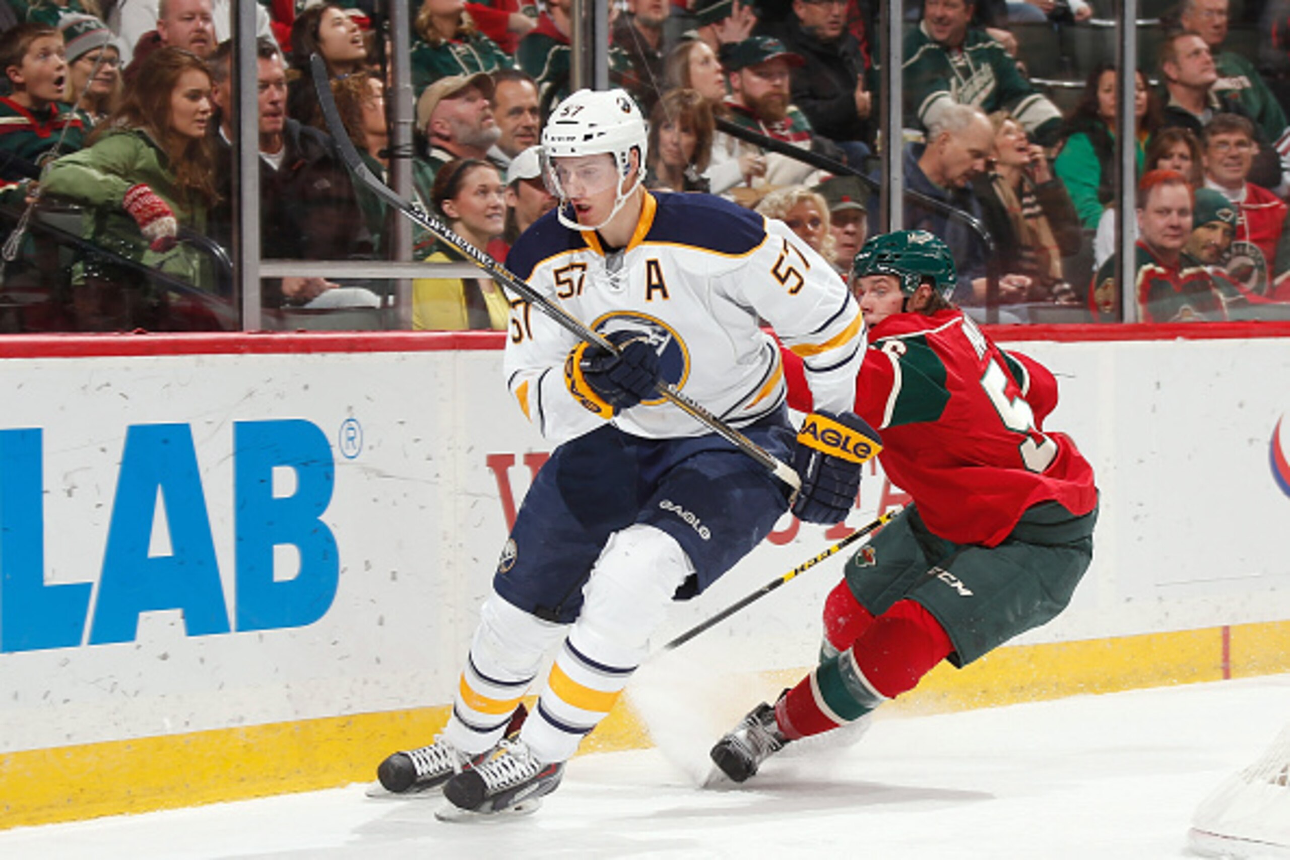 ST. PAUL, MN - NOVEMBER 13: Tyler Myers #57 of the Buffalo Sabres and Erik Haula #56 of the Minnesota Wild skate to the puck during the game on November 13, 2014 at the Xcel Energy Center in St. Paul, Minnesota. (Photo by Bruce Kluckhohn/NHLI via Getty Im