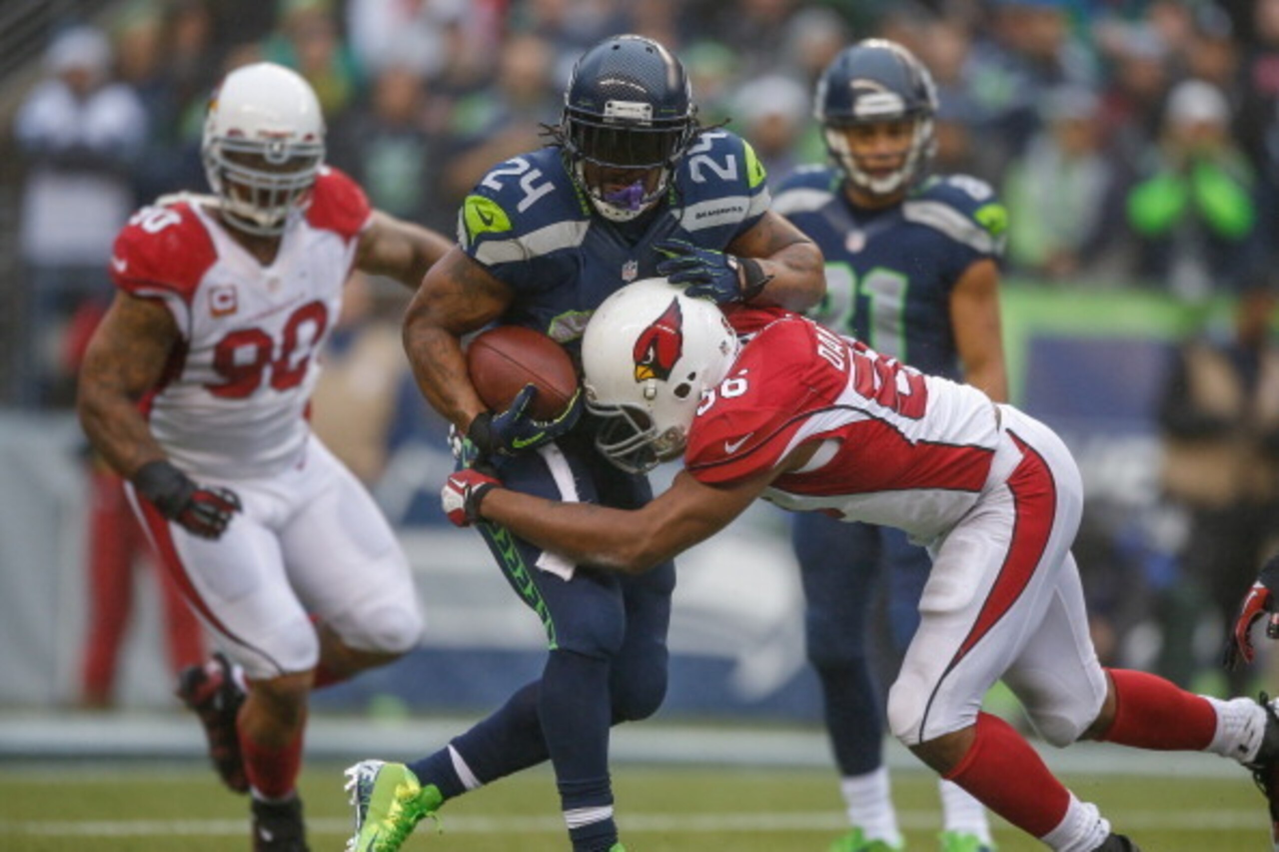 SEATTLE, WA - DECEMBER 22:  Running back Marshawn Lynch #24 of the Seattle Seahawks rushes against linebacker Karlos Dansby #56 of the Arizona Cardinals at CenturyLink Field on December 22, 2013 in Seattle, Washington.  (Photo by Otto Greule Jr/Getty Imag