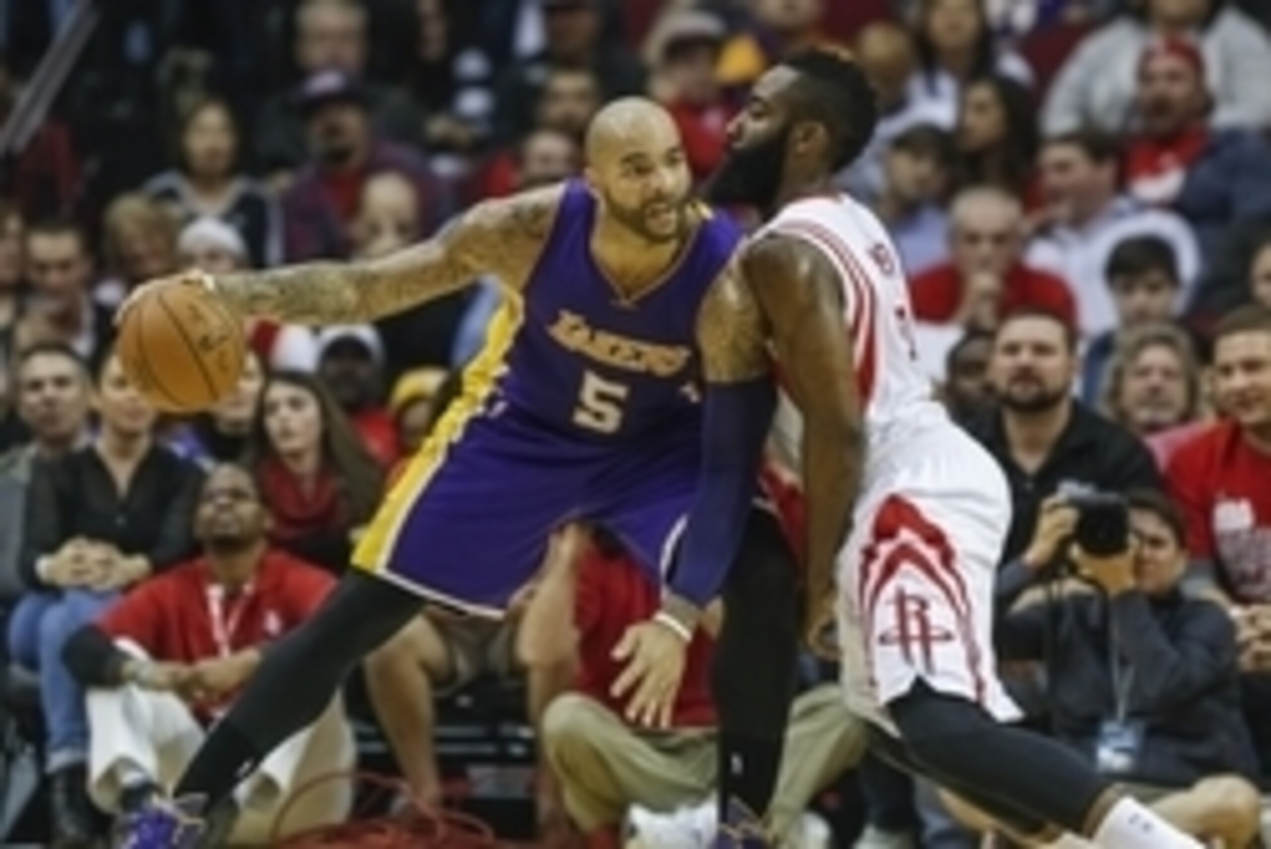 Nov 19, 2014; Houston, TX, USA; Los Angeles Lakers forward Carlos Boozer (5) dribbles the ball as Houston Rockets guard James Harden (13) defends during the first quarter at Toyota Center. Mandatory Credit: Troy Taormina-USA TODAY Sports