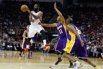 HOUSTON, TX - NOVEMBER 19:  James Harden #13 of the Houston Rockets looks to pass in front of Wesley Johnson #11 and Kobe Bryant #24 of the Los Angeles Lakers during their game at the Toyota Center on November 19, 2014 in Houston, Texas.  NOTE TO USER: Us
