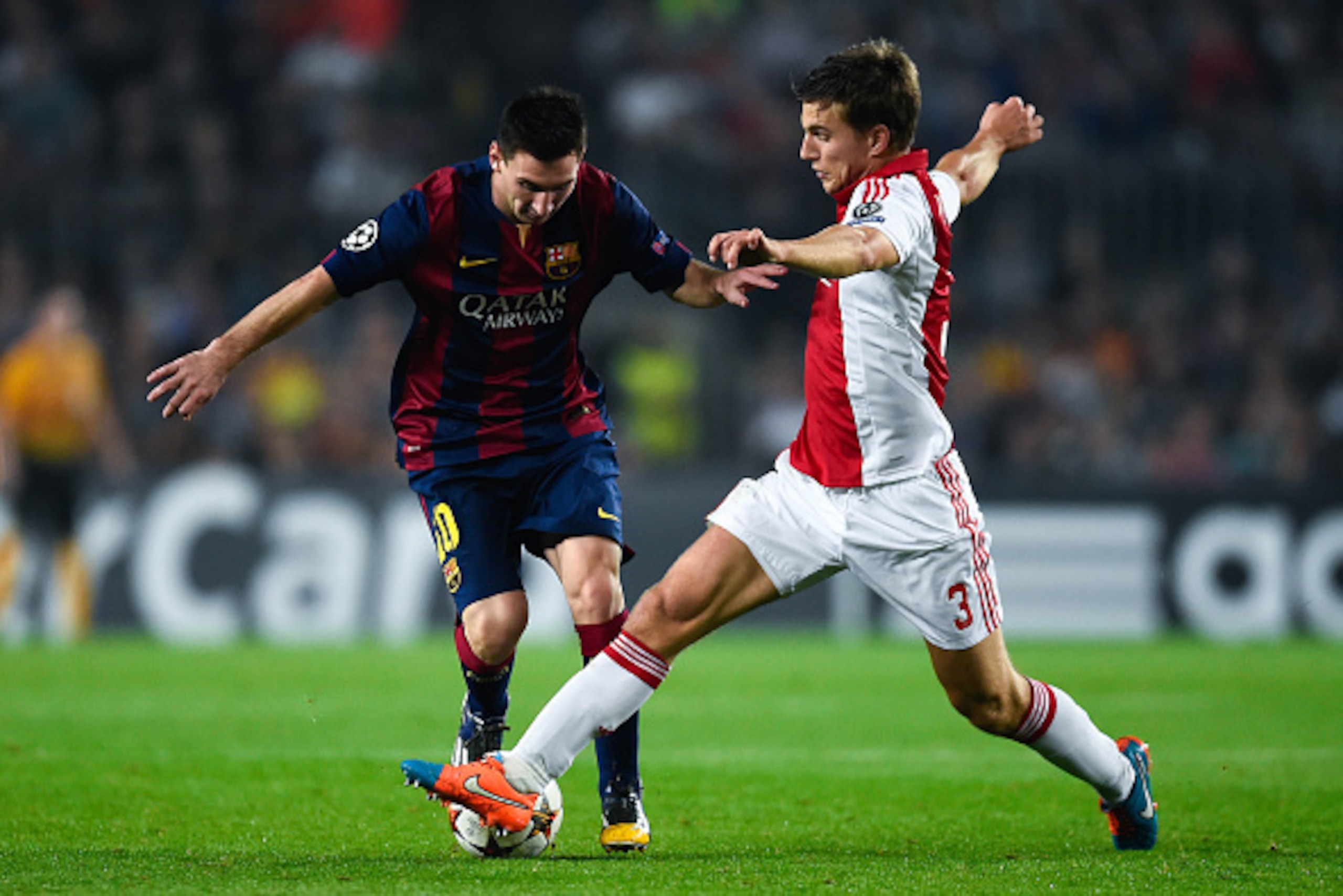 BARCELONA, SPAIN - OCTOBER 21:  Lionel Messi of FC Barcelona competes for the ball with Joel Veltman of AFC Ajax during a UEFA Champions League Group F match between FC Barcelona and AFC Ajax at the Camp Nou Stadium on October 21, 2014 in Barcelona, Spain