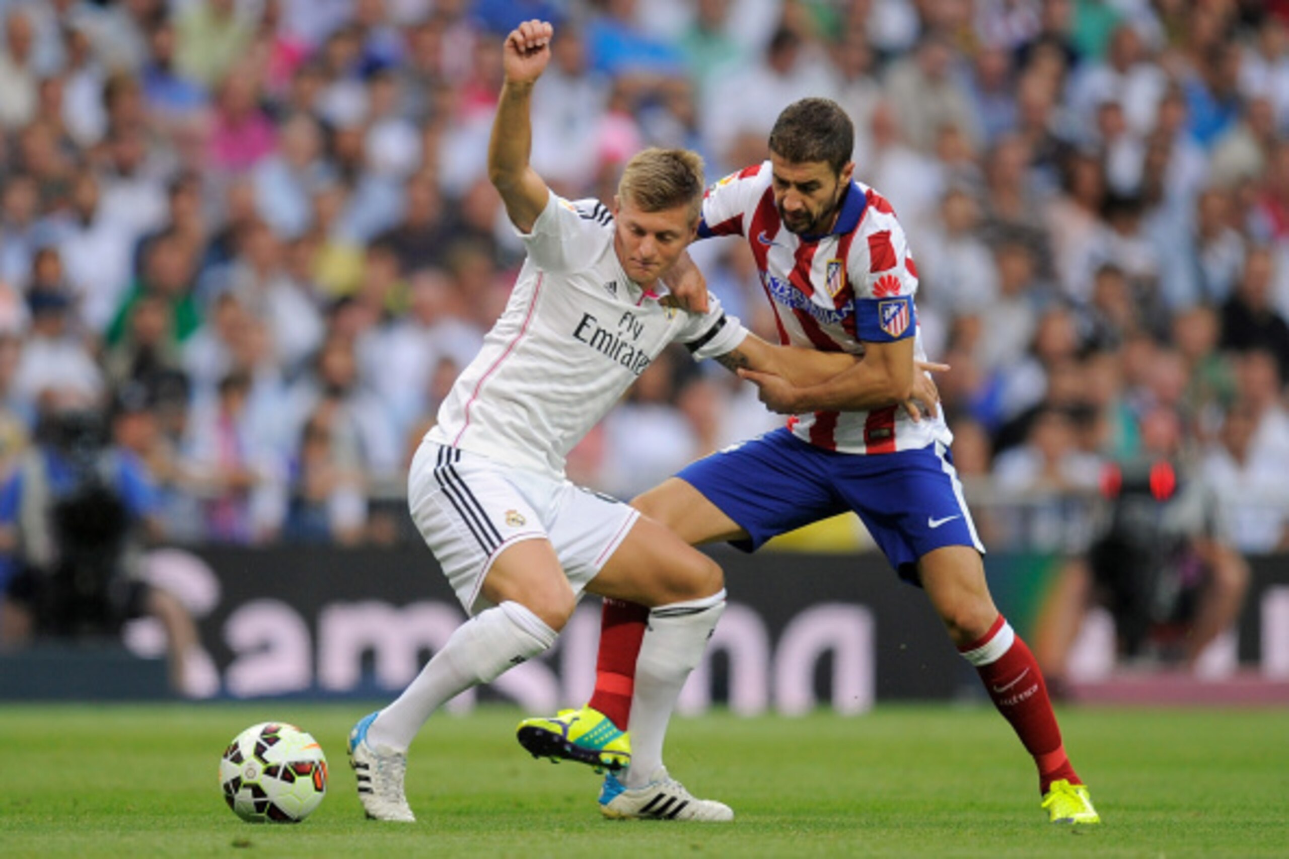 MADRID, SPAIN - SEPTEMBER 13:  Toni Kroos (L) of Real Madrid is fouled  by Gabi Fernandez of Atletico de Madrid during the La Liga match between Real Madrid and Atletico de Madrid at Estadio Santiago Bernabeu on September 13, 2014 in Madrid, Spain.  (Phot