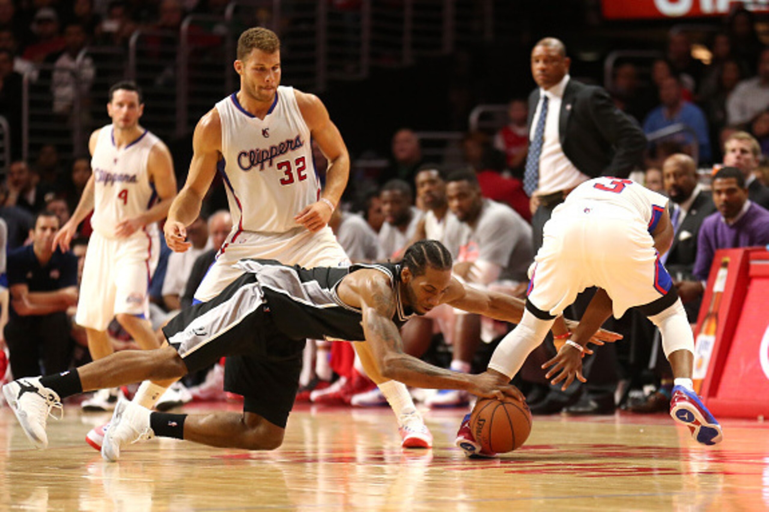 LOS ANGELES, CA - NOVEMBER 10: Kawhi Leonard #2 of the San Antonio Spurs steals the ball from Chris Paul #3 of the Los Angeles Clippers and dives to control it from Paul and Blake Griffin #32 with 51 seconds left in the game at Staples Center on November 
