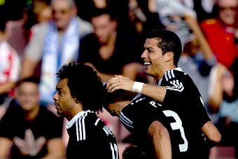 GRANADA, SPAIN - NOVEMBER 01: Cristiano Ronaldo (R) of Real Madrid CF celebrates scoring their opening goal with Karim Benzema (2ndR) and Marcelo (L)  during the La Liga match between Granada CF and Real Madrid CF at Nuevo Estadio de Los Carmenes on Novem
