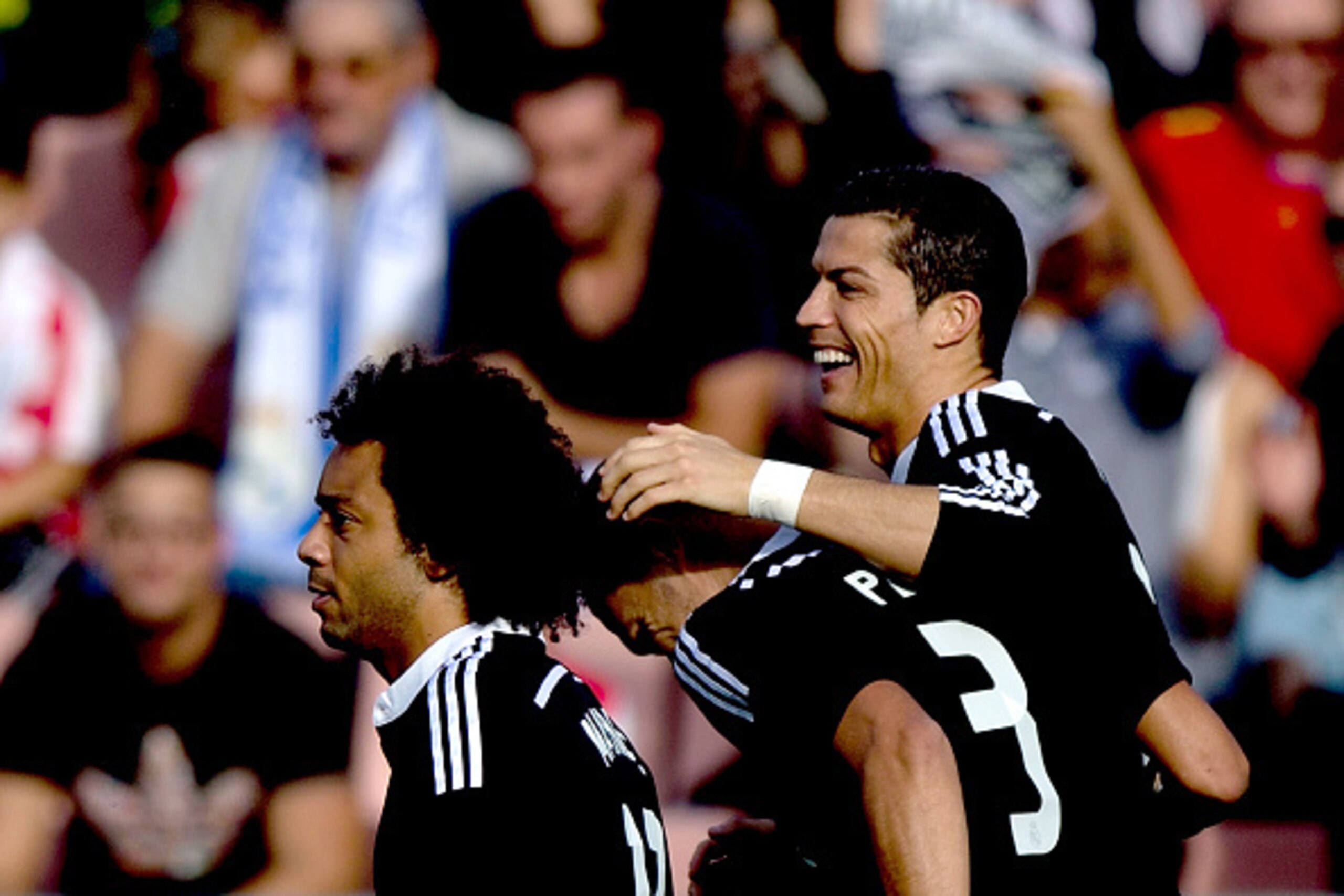 GRANADA, SPAIN - NOVEMBER 01: Cristiano Ronaldo (R) of Real Madrid CF celebrates scoring their opening goal with Karim Benzema (2ndR) and Marcelo (L)  during the La Liga match between Granada CF and Real Madrid CF at Nuevo Estadio de Los Carmenes on Novem