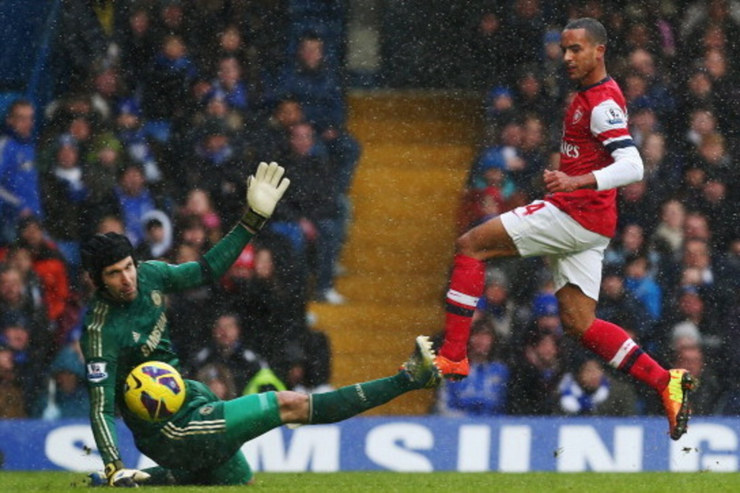 LONDON, ENGLAND - JANUARY 20:  Petr Cech of Chelsea attempts to stop Theo Walcott of Arsenal during the Barclays Premier League match between Chelsea and Arsenal at Stamford Bridge on January 20, 2013 in London, England.  (Photo by Clive Rose/Getty Images