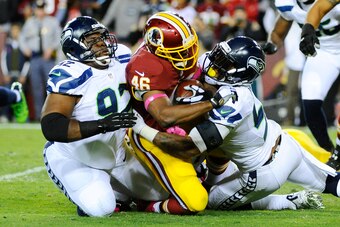 Oct 6, 2014; Landover, MD, USA; Washington Redskins running back Alfred Morris (46) carries the ball as Seattle Seahawks defensive tackle Brandon Mebane (92) and outside linebacker Bruce Irvin (51) tackle in the second quarter at FedEx Field. Mandatory Cr