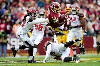 LANDOVER, MD - NOVEMBER 16:  Quarterback Robert Griffin III #10 of the Washington Redskins takes a second quarter hit from defensive back Brandon Dixon #39 of the Tampa Bay Buccaneers at FedExField on November 16, 2014 in Landover, Maryland.  (Photo by Pa