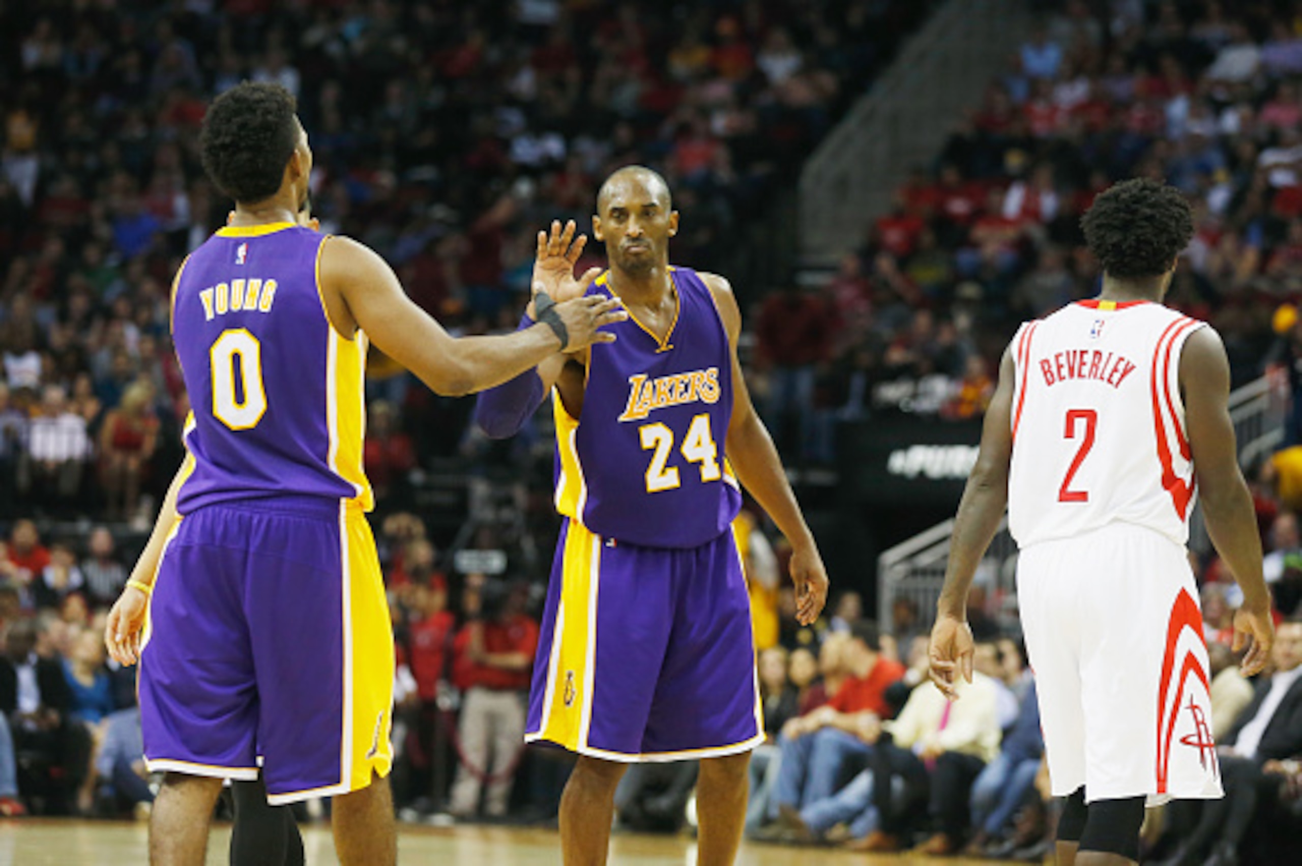 HOUSTON, TX - NOVEMBER 19:  Kobe Bryant #24 of the Los Angeles Lakers celebrates a play with Nick Young #0 as Patrick Beverley #2 of the Houston Rockets walks away during their game at the Toyota Center on November 19, 2014 in Houston, Texas.  NOTE TO USE
