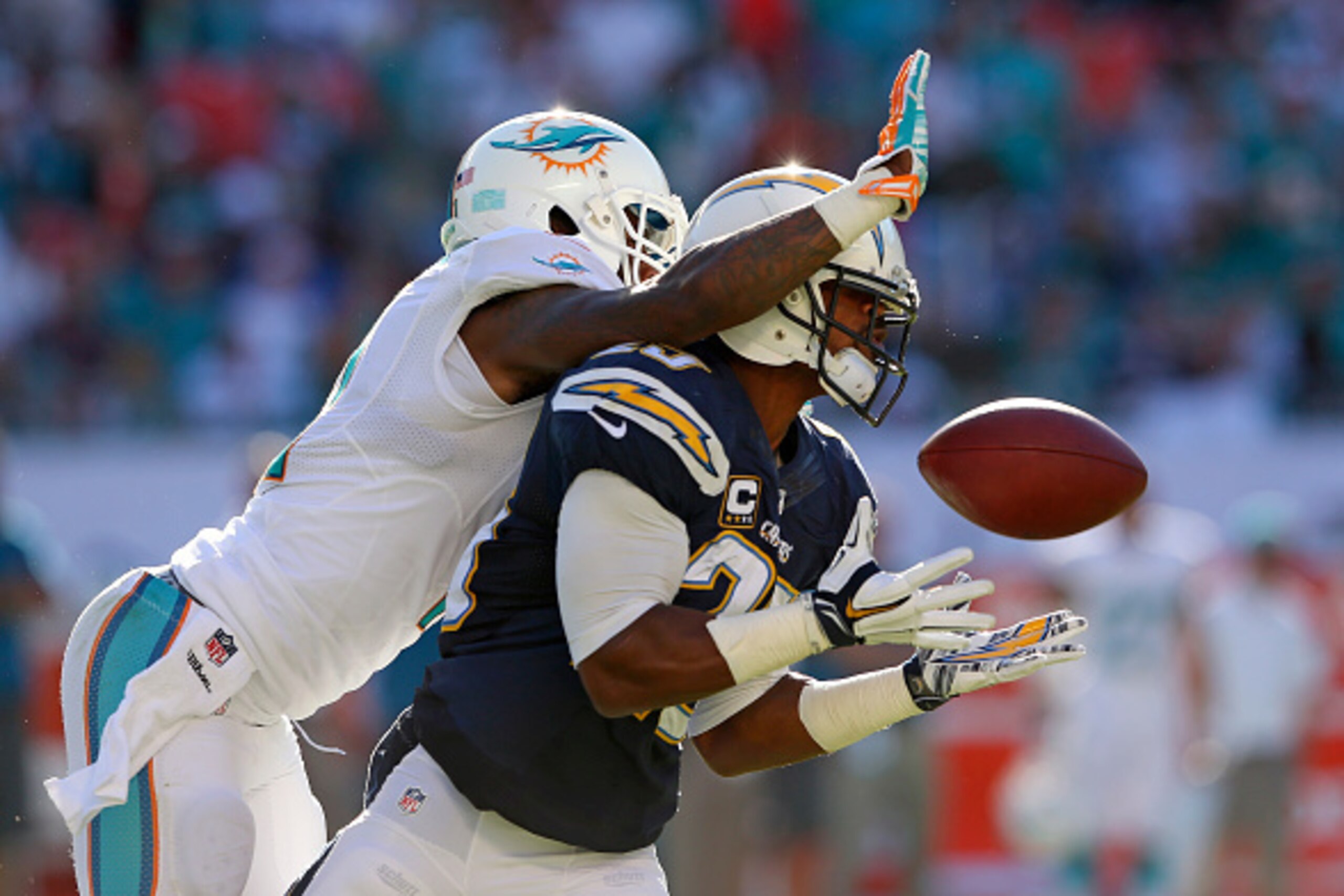 MIAMI GARDENS, FL - NOVEMBER 02:  wide receiver Mike Wallace #11 of the Miami Dolphins knocks a potential interception away from defender Darrell Stuckey #25 of the San Diego Chargers in the second half of a game at Sun Life Stadium on November 2, 2014 in