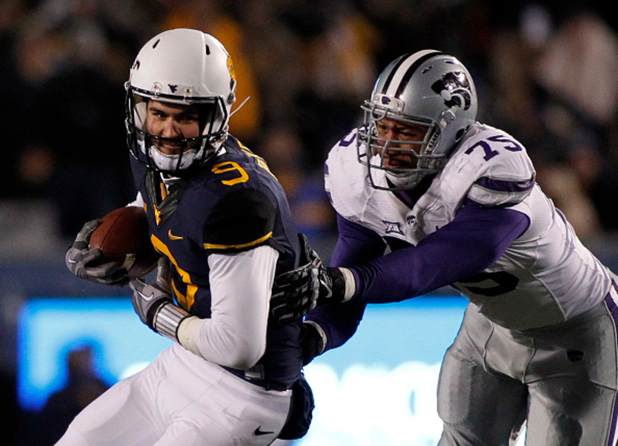 MORGANTOWN, WV - NOVEMBER 20:  Clint Trickett #9 of the West Virginia Mountaineers is sacked by Jordan Willis #75 of the Kansas State Wildcats in the second quarter during the game on November 20, 2014 at Mountaineer Field in Morgantown, West Virginia.  (