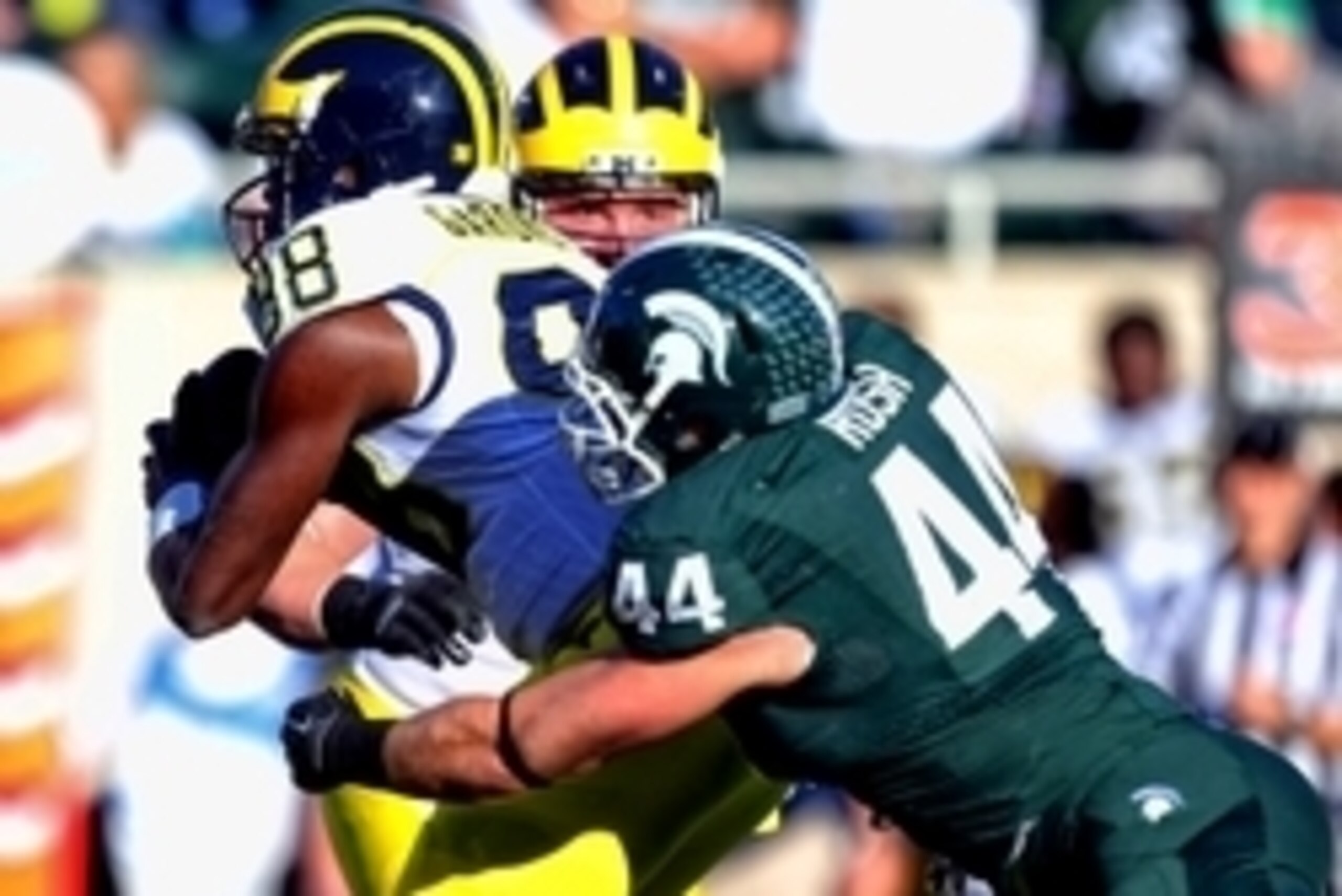 Oct 25, 2014; East Lansing, MI, USA; Michigan Wolverines quarterback Devin Gardner (98) is sacked by Michigan State Spartans defensive end Marcus Rush (44) during the first half of a game at Spartan Stadium. Mandatory Credit: Mike Carter-USA TODAY Sports