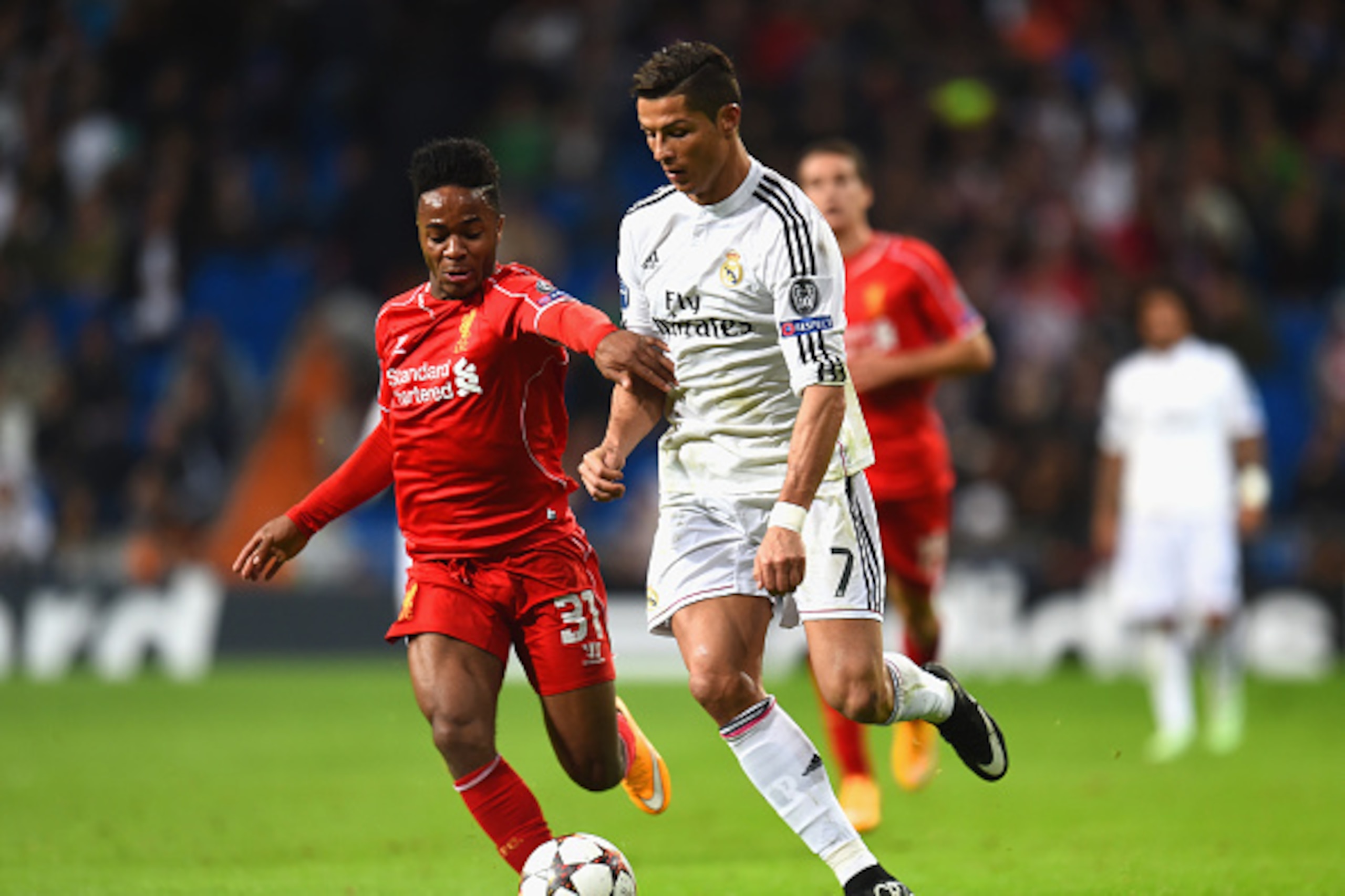 MADRID, SPAIN - NOVEMBER 04:  Raheem Sterling of Liverpool and Cristiano Ronaldo of Real Madrid CF battle for the ball during the UEFA Champions League Group B match between Real Madrid CF and Liverpool FC at Estadio Santiago Bernabeu on November 4, 2014 