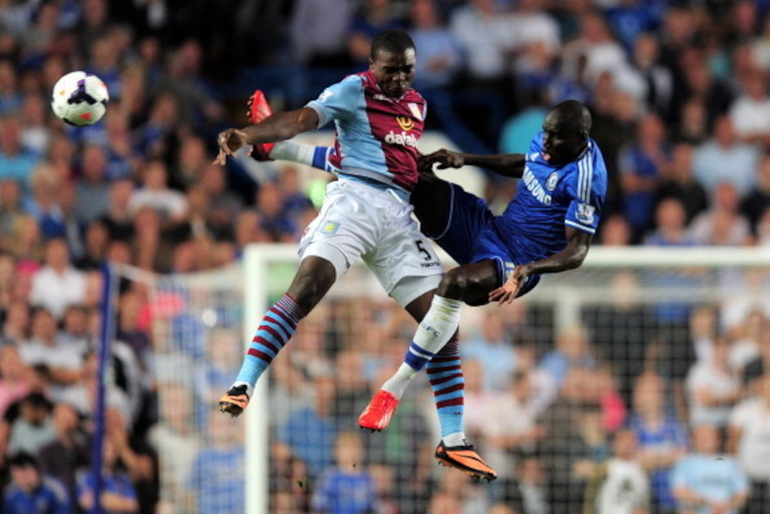 LONDON, ENGLAND - AUGUST 21:  Jores Okore of Aston Villa and Demba Ba of Chelsea compete for the ball during the Barclays Premier League match between Chelsea and Aston Villa at Stamford Bridge on August 21, 2013 in London, England.  (Photo by Jamie McDon