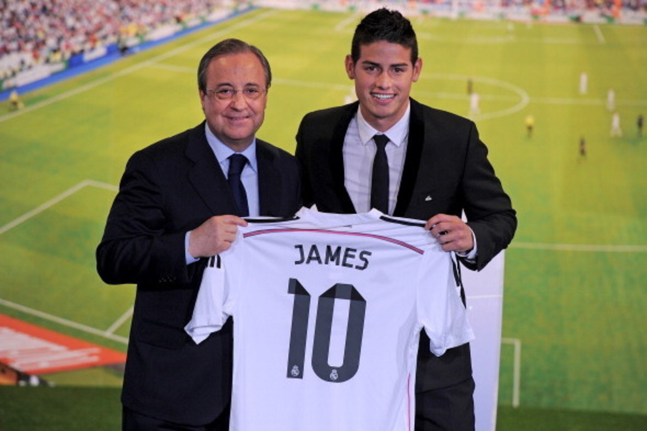 MADRID, SPAIN - JULY 22:  James Rodriguez holds his new Real shirt beside club president Florentino Perez during his unveiling as a new Real Madrid player at the Santaigo Bernabeu stadium on July 22, 2014 in Madrid, Spain. Real agreed to buy Rodriguez fro