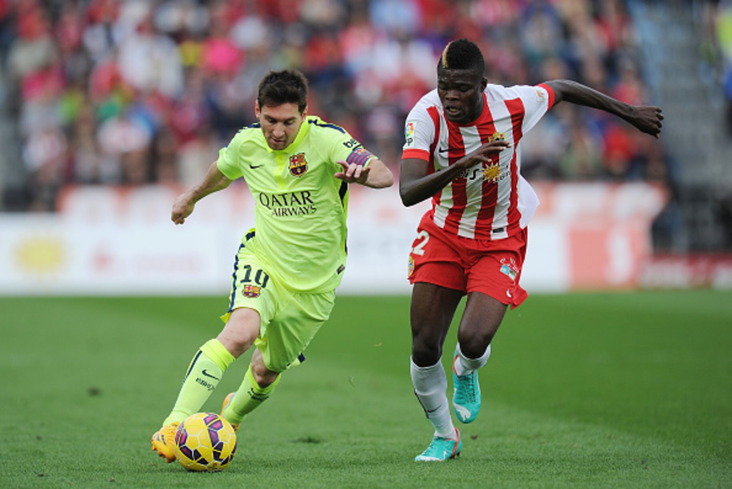 ALMERIA, SPAIN - NOVEMBER 08:  Lionel Messi of FC Barcelona is challenged by Thomas Partey of UD Almeria during the La Liga match between UD Almeria and FC Barcelona at estadio de los Juegos Mediterraneos on November 8, 2014 in Almeria, Spain.  (Photo by 