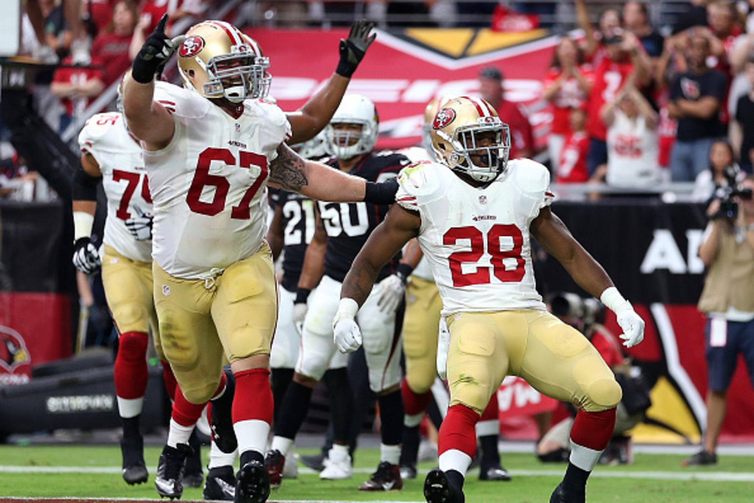 GLENDALE, AZ - SEPTEMBER 21: Running back Carlos Hyde #28 of the San Francisco 49ers celebrates a second-quarter touchdown with center Daniel Kilgore #67 during the NFL game against the Arizona Cardinals at the University of Phoenix Stadium on September 2