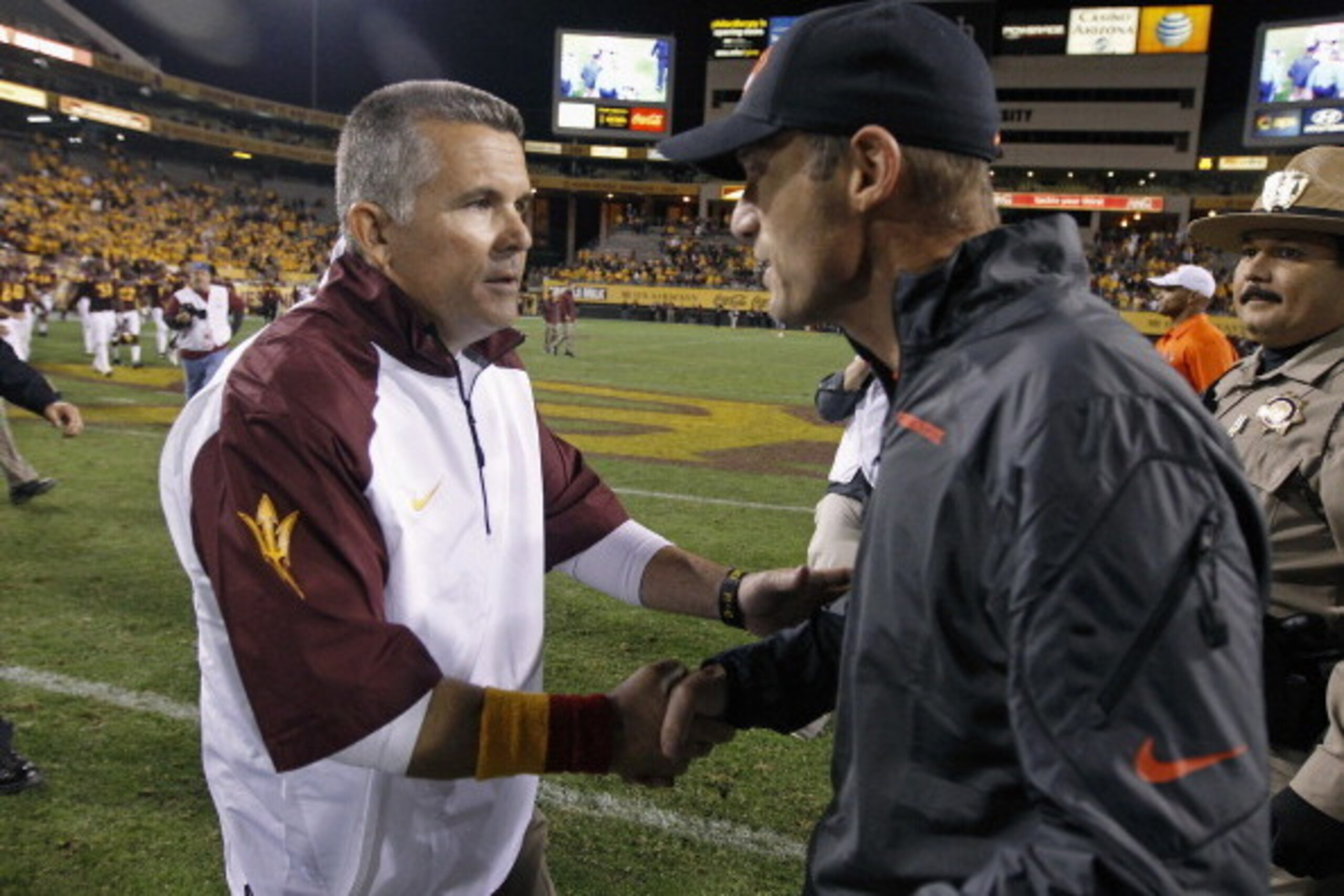 TEMPE, AZ - NOVEMBER 16:  Head coach Todd Graham of the Arizona State Sun Devils (left) and head coach Mike Riley of the Oregon State Beavers exchange handshakes at midfield after their college football game at Sun Devil Stadium on November 16, 2013 in Te