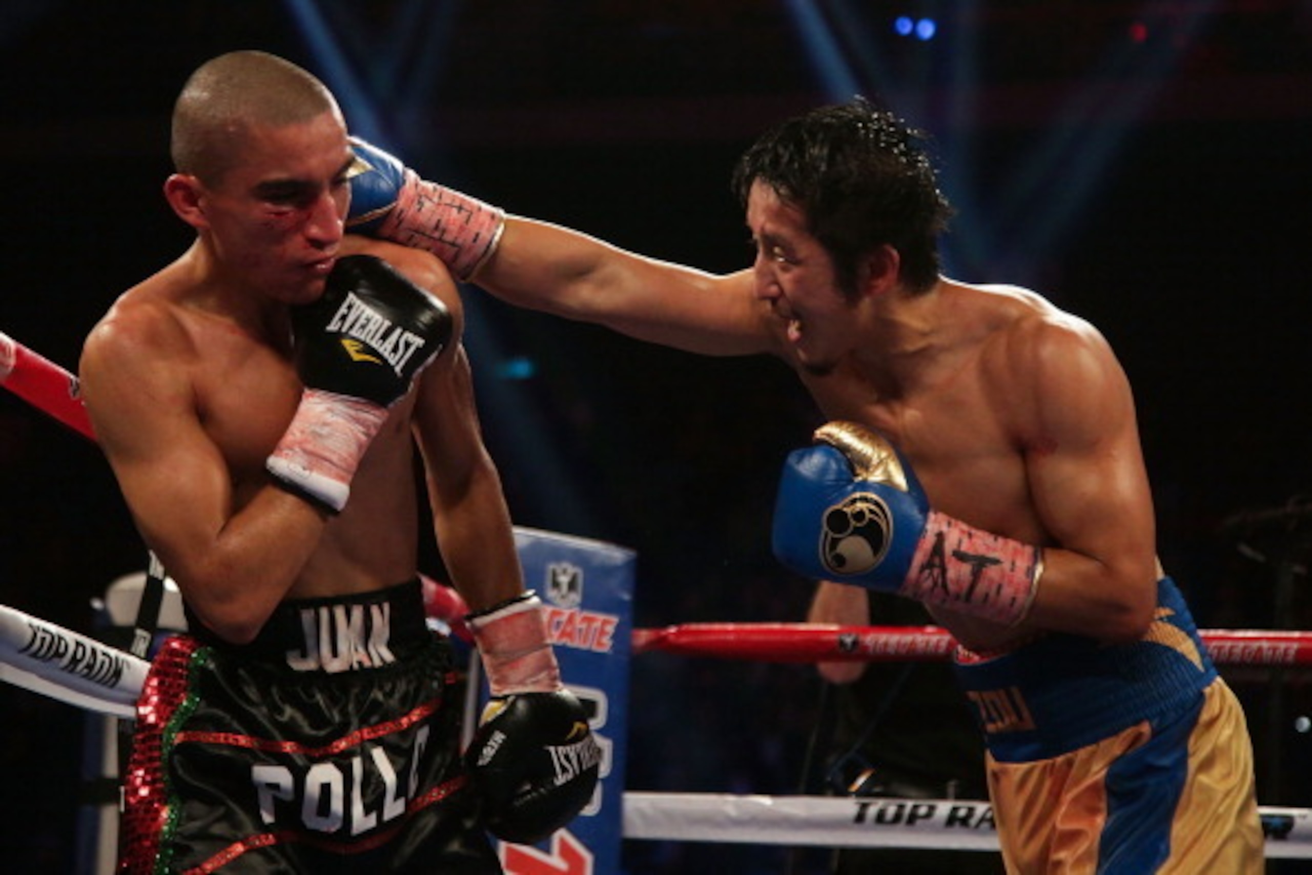 MACAU - NOVEMBER 24:  Zou Shiming (R) of China fights with Juan 'Pollo' Tozcano of Mexico during their 'Clash in Cotai' flyweight bout on November 24, 2013 in Macau.  (Photo by Nicky Loh/Getty Images)