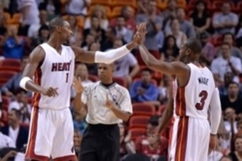 Oct 21, 2014; Miami, FL, USA; Miami Heat forward Chris Bosh (left) greets guard Dwyane Wade (right) during the first half against the Houston Rockets at American Airlines Arena. Mandatory Credit: Steve Mitchell-USA TODAY Sports