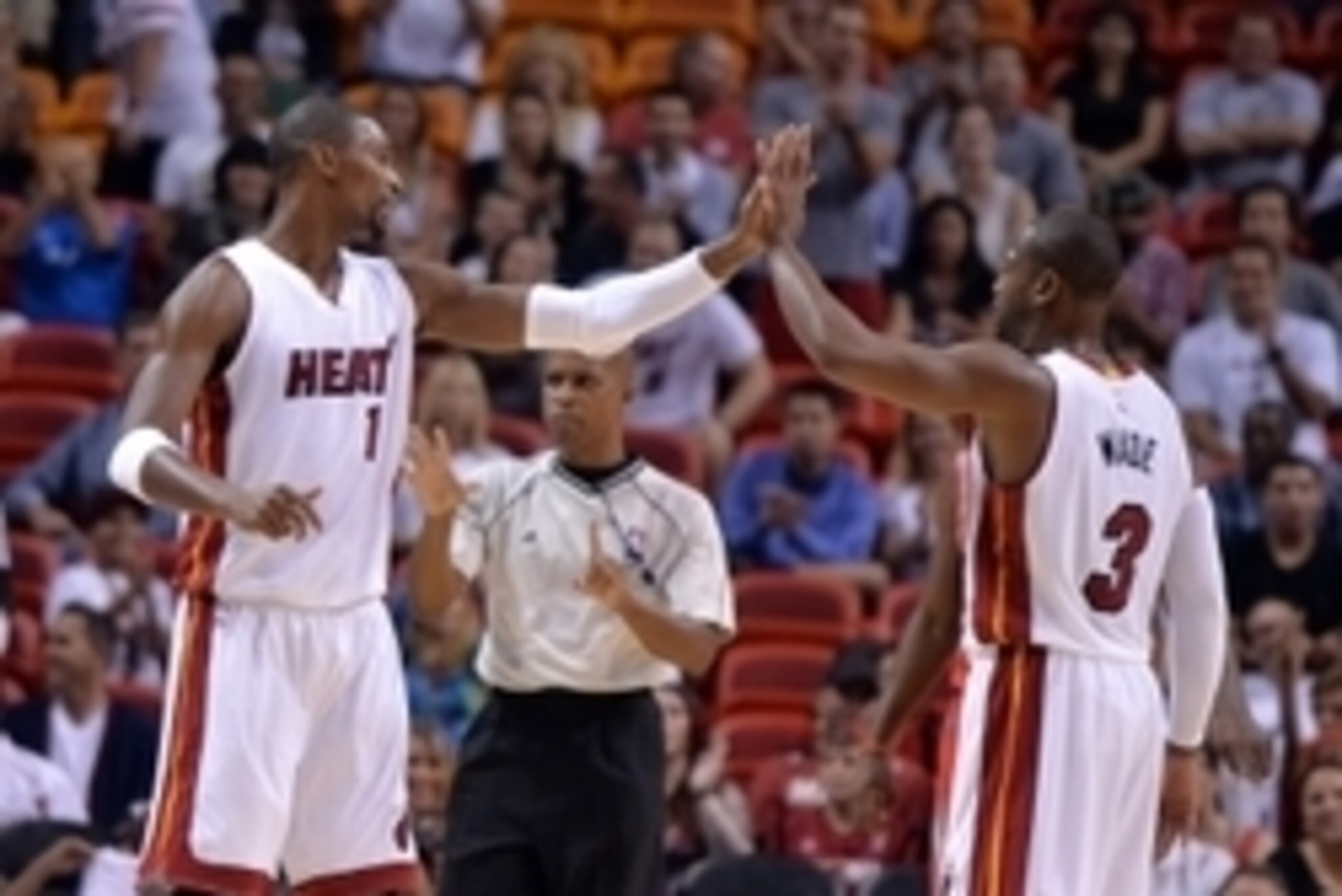 Oct 21, 2014; Miami, FL, USA; Miami Heat forward Chris Bosh (left) greets guard Dwyane Wade (right) during the first half against the Houston Rockets at American Airlines Arena. Mandatory Credit: Steve Mitchell-USA TODAY Sports