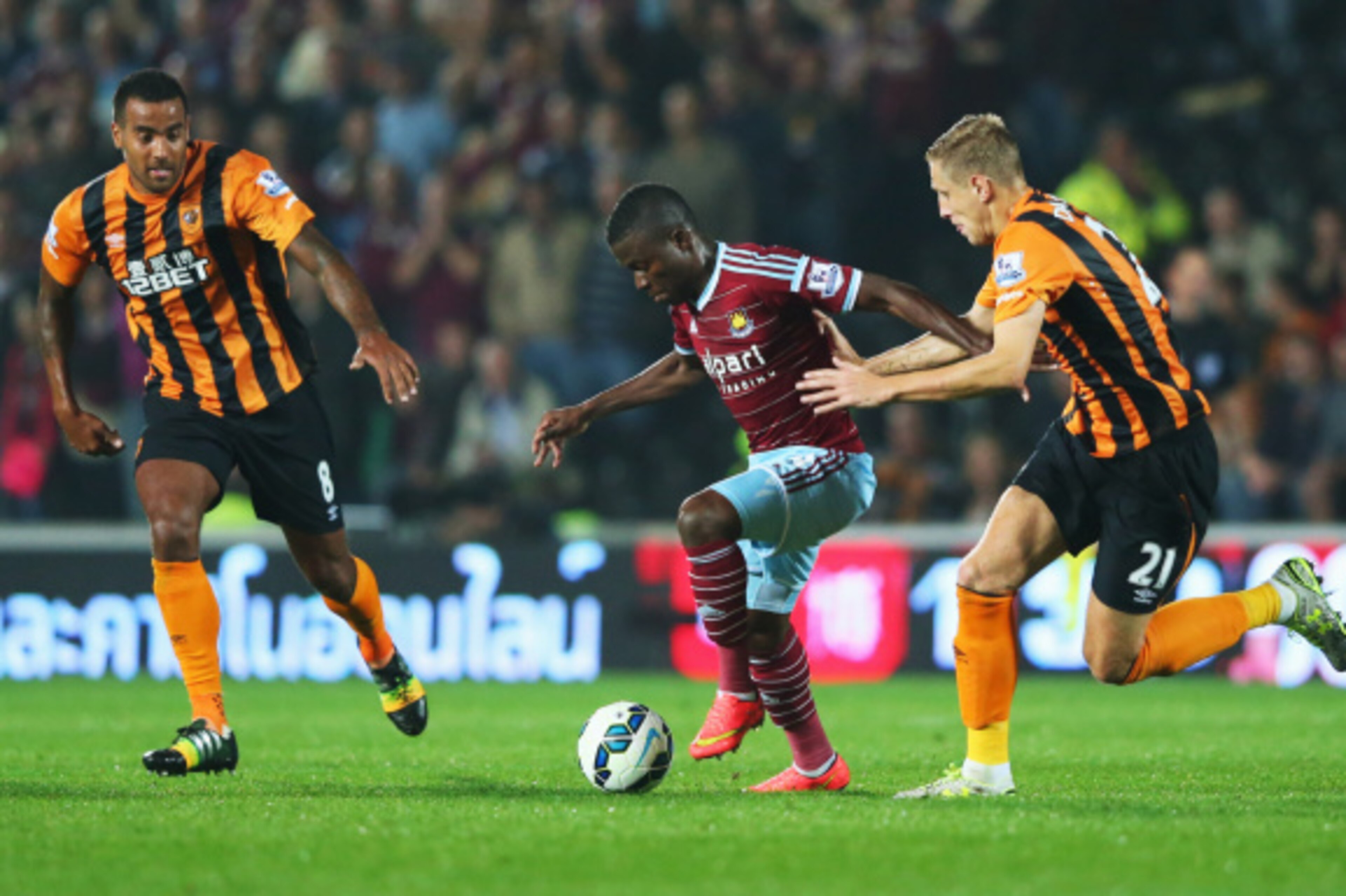 HULL, ENGLAND - SEPTEMBER 15:  Enner Valencia of West Ham United goes between Tom Huddlestone (8) and Michael Dawson (21) of Hull City during Barclays Premier League match between Hull City and West Ham United at KC Stadium on September 15, 2014 in Hull, 