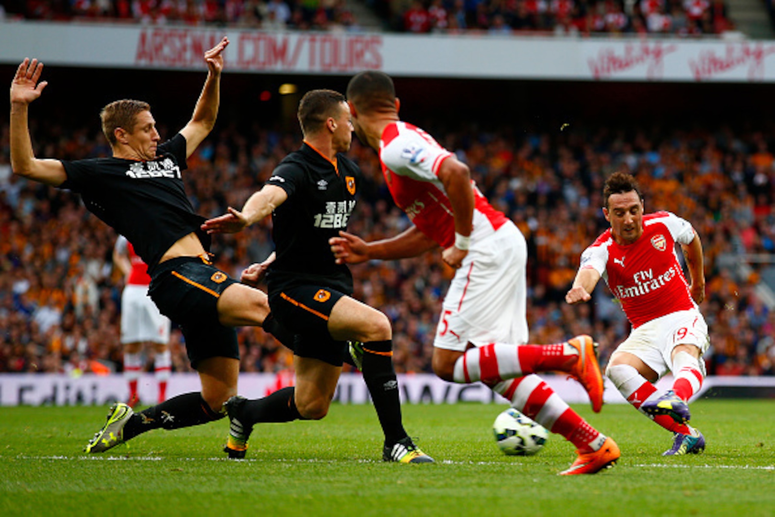 LONDON, ENGLAND - OCTOBER 18: Santi Cazorla of Arsenal attempts to shoot past Michael Dawson and James Chester of Hull City during the Barclays Premier League match between Arsenal and Hull City at Emirates Stadium on October 18, 2014 in London, England. LONDON, ENGLAND - OCTOBER 18: Santi Cazorla of Arsenal attempts to shoot past Michael Dawson and James Chester of Hull City during the Barclays Premier League match between Arsenal and Hull City at Emirates Stadium on October 18, 2014 in London, England.