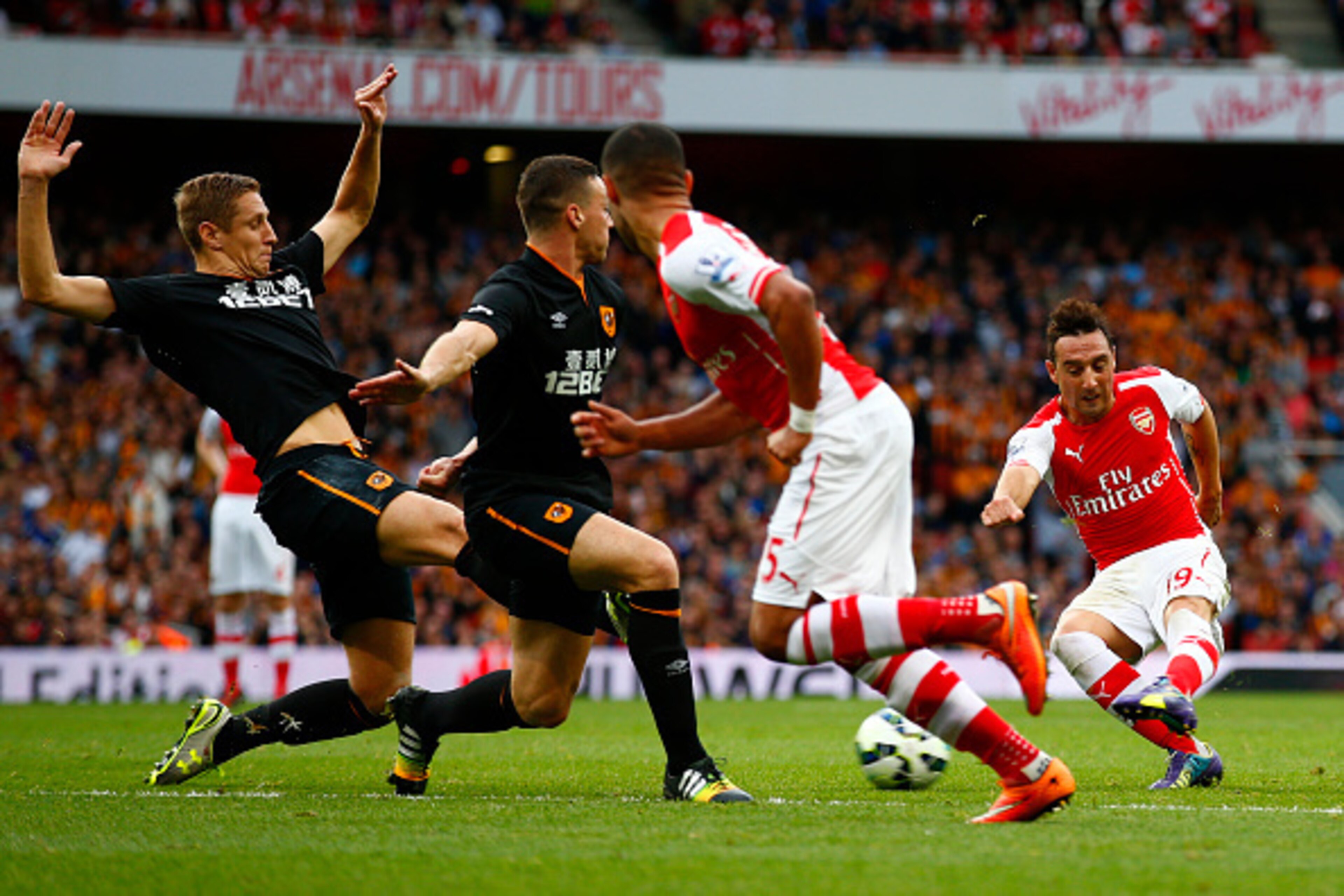 LONDON, ENGLAND - OCTOBER 18:  Santi Cazorla of Arsenal attempts to shoot past Michael Dawson and James Chester of Hull City during the Barclays Premier League match between Arsenal and Hull City at Emirates Stadium on October 18, 2014 in London, England.