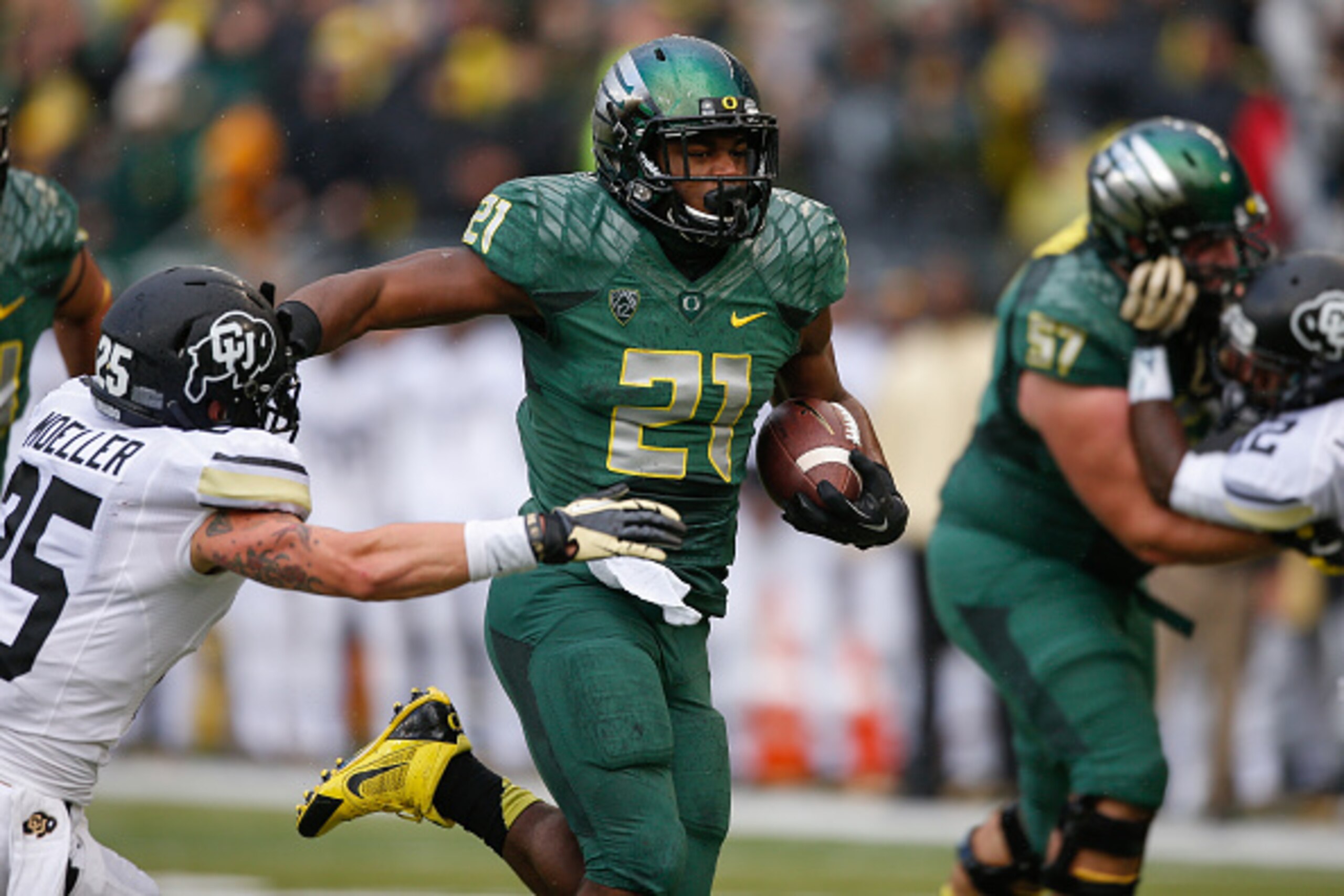 EUGENE, OR - NOVEMBER 22:  Running back Royce Freeman #21 of the Oregon Ducks rushes for a touchdown against Ryan Moeller #25 of the Colorado Buffaloes in the first quarter at Autzen Stadium on November 22, 2014 in Eugene, Oregon.  (Photo by Otto Greule J