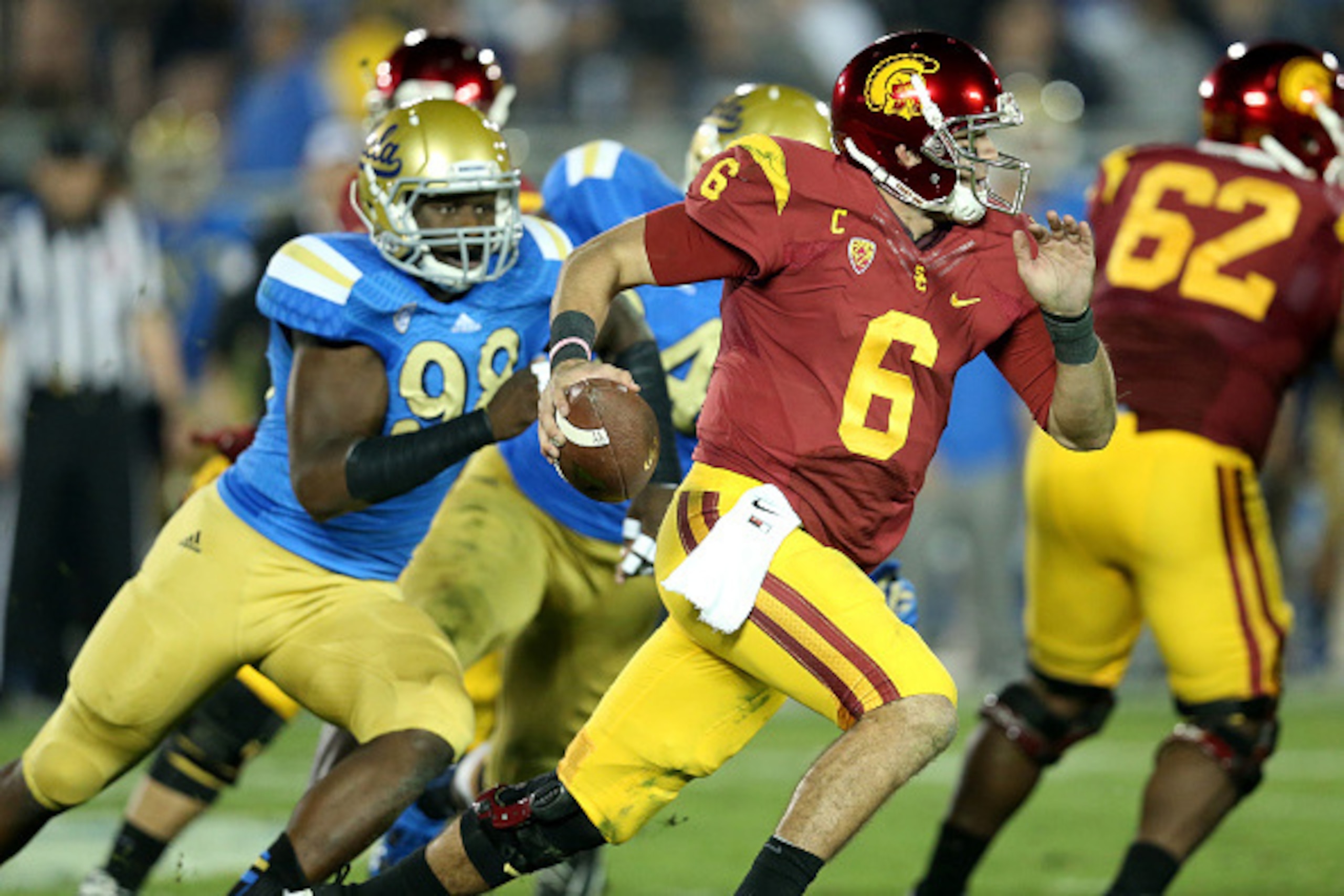 PASADENA, CA - NOVEMBER 22:  Quarterback Cody Kessler #6 of the USC Trojans scrambles away from defensive lineman Takkarist McKinley #98 of the UCLA Bruins in the third quarter at the Rose Bowl on November 22, 2014 in Pasadena, California.  (Photo by Step