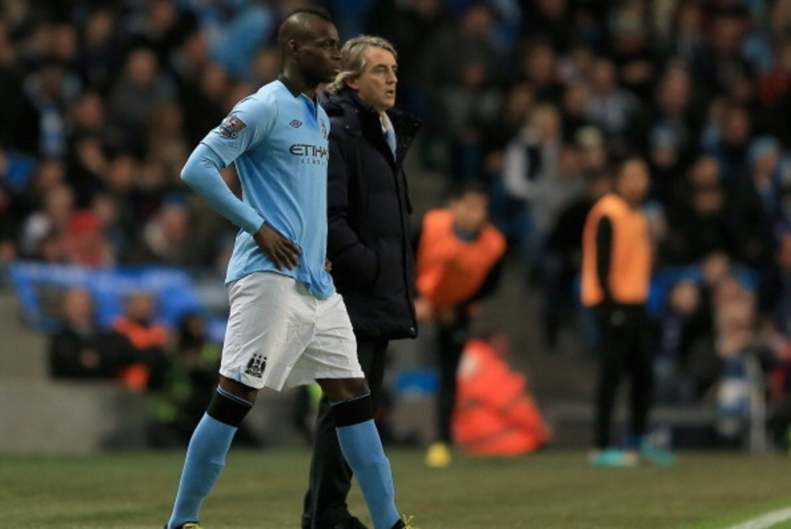 MANCHESTER, ENGLAND - JANUARY 05:  Mario Balotelli of Manchester City stands with manager Roberto Mancini as he prepares to come on during the FA Cup with Budweiser Third Round match between Manchester City and Watford at The Etihad Stadium on January 5, 