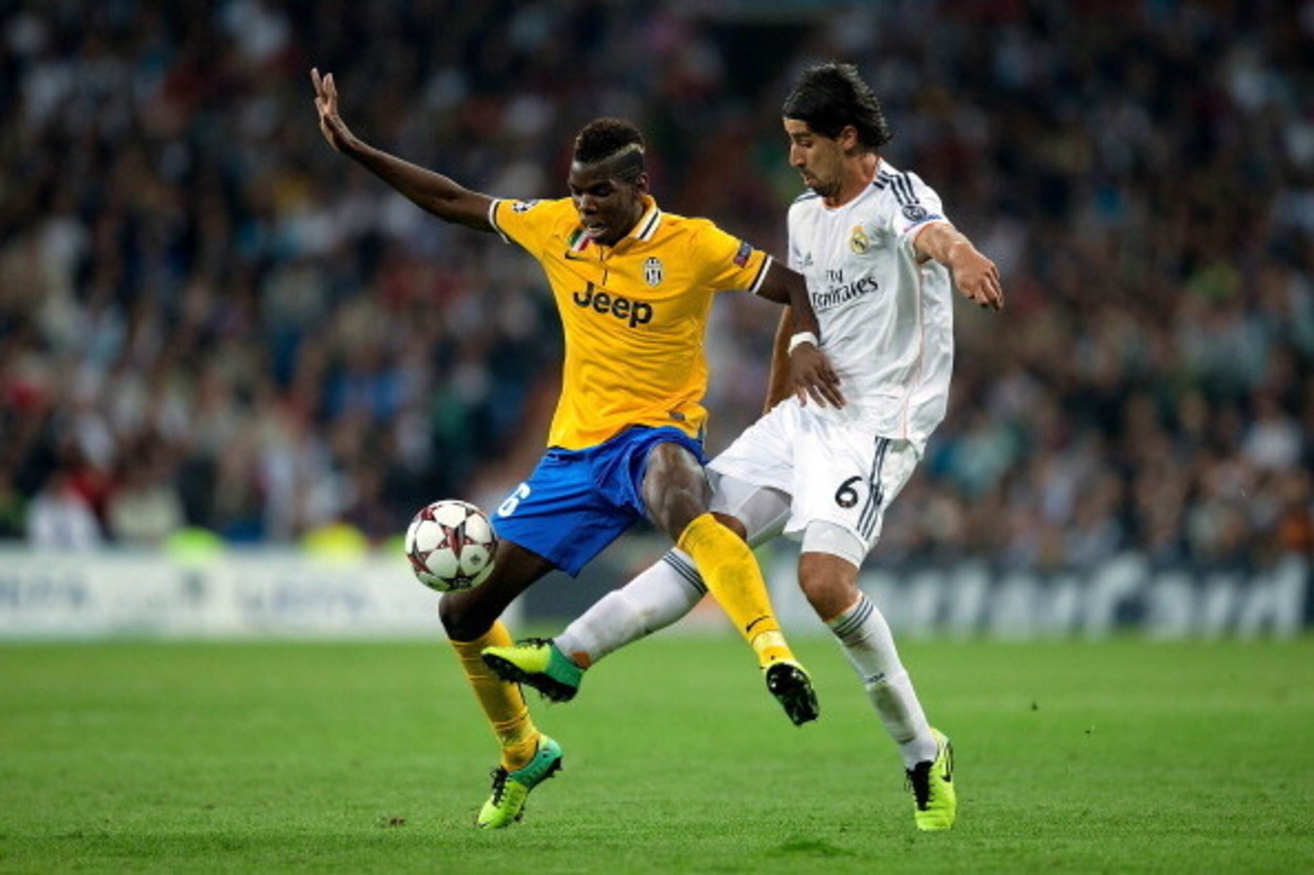 MADRID, SPAIN - OCTOBER 23: Paul Pogba (L) of Juventus competes for the ball with Sami Khedira (R) of Real Madrid CF during the  UEFA Champions League Group B match between Real Madrid CF and Juventus at Estadio Santiago Bernabeu on October 23, 2013 in Ma