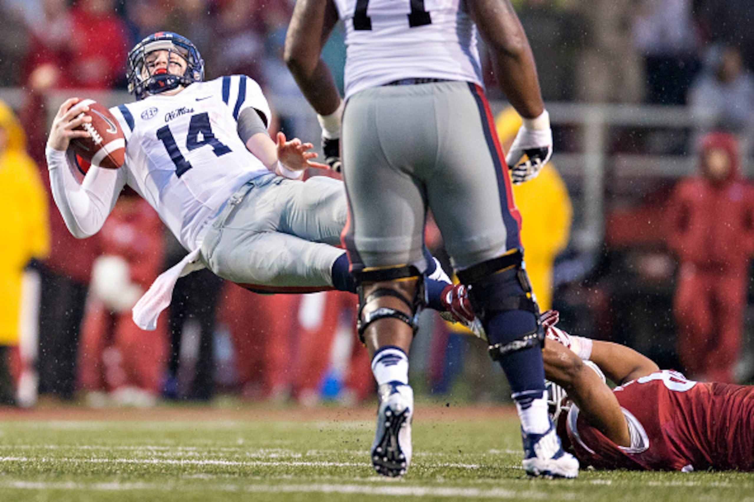 FAYETTEVILLE, AR - NOVEMBER 22: Bo Wallace #14 of the Ole Miss Rebels is tackled in the third quarter against the Arkansas Razorbacks at Razorback Stadium on November 22, 2014 in Fayetteville, Arkansas. The Razorbacks defeated the Rebels 30-0. (Photo b FAYETTEVILLE, AR - NOVEMBER 22: Bo Wallace #14 of the Ole Miss Rebels is tackled in the third quarter against the Arkansas Razorbacks at Razorback Stadium on November 22, 2014 in Fayetteville, Arkansas. The Razorbacks defeated the Rebels 30-0. (Photo b