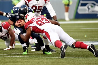 SEATTLE, WA - NOVEMBER 23:   Calais Campbell #93 of the Arizona Cardinals tackles Russell Wilson #3 of the Seattle Seahawks during their game at CenturyLink Field on November 23, 2014 in Seattle, Washington.  (Photo by Steve Dykes/Getty Images)