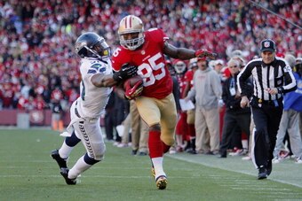 SAN FRANCISCO, CA - DECEMBER 08:  Tight end Vernon Davis #85 of the San Francisco 49ers picks up 13 yards and a first down against linebacker Bruce Irvin #51 of the Seattle Seahawks reaching the six yard line to set up his touchdown in the second quarter 