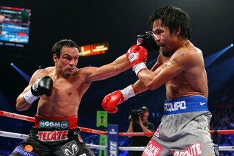 LAS VEGAS, NV - DECEMBER 08:  (L-R) Juan Manuel Marquez throws a left to the face of Manny Pacquiao during their welterweight bout at the MGM Grand Garden Arena on December 8, 2012 in Las Vegas, Nevada.  (Photo by Al Bello/Getty Images)