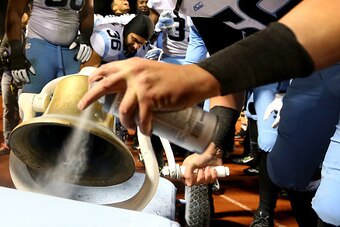DURHAM, NC - NOVEMBER 20:  Alex Marrs #56 of the North Carolina Tar Heels paints the victory bell after defeating the Duke Blue Devils 45-20 at Wallace Wade Stadium on November 20, 2014 in Durham, North Carolina.  (Photo by Streeter Lecka/Getty Images)