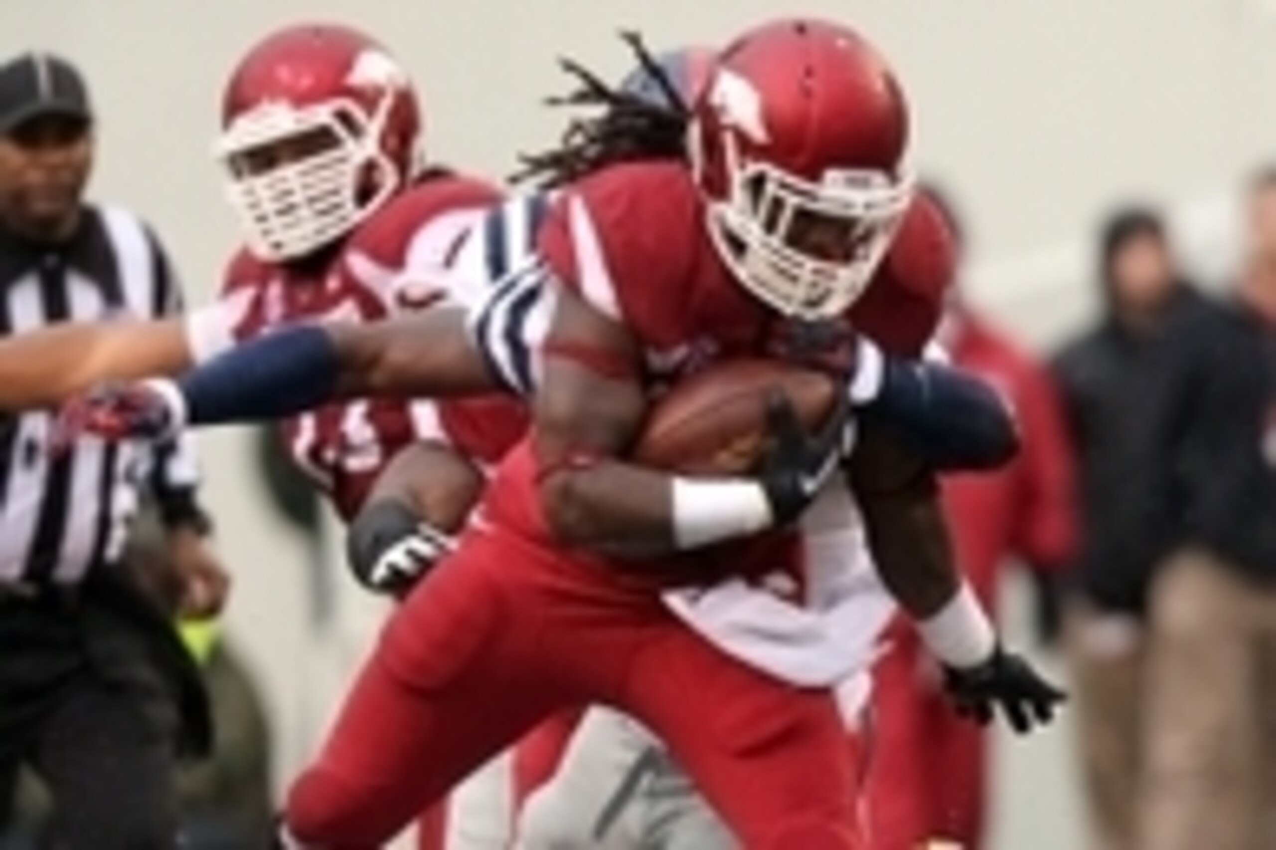 Nov 22, 2014; Fayetteville, AR, USA; Arkansas Razorbacks running back Alex Collins (3) jumps over Ole Miss Rebels defensive back Trae Elston (7) during the first half at Donald W. Reynolds Razorback Stadium. Mandatory Credit: Nelson Chenault-USA TODAY Spo