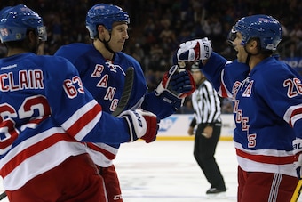 NEW YORK, NY - OCTOBER 03: Matt Hunwick #44 of the New York Rangers (C) celebrates his second period goal against the Chicago Blackhawks along with Anthony Duclair #63 (L) and Martin St. Louis #26 (R) at Madison Square Garden on October 3, 2014 in New Yor