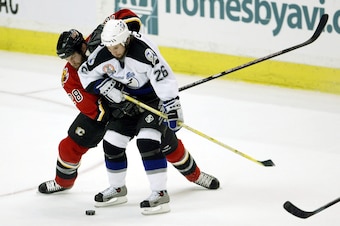 CALGARY, CANADA - JUNE 5:  Robyn Regehr #28 of the Calgary Flames rides the back of Martin St. Louis #26 of the Tampa Bay Lightning in game six of the 2004 NHL Stanley Cup Finals on June 5, 2004 at the Pengrowth Saddledome in Calgary, Canada.  (Photo by J