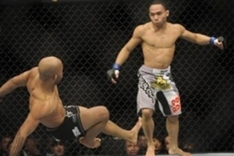 Jan 26, 2013; Chicago, IL, USA; Demetrious Johnson (black shorts) is knocked down by John Dodson (white shorts) during UFC on FOX 6 for the world flyweight championship at the United Center.  Mandatory Credit: David Banks-USA TODAY Sports