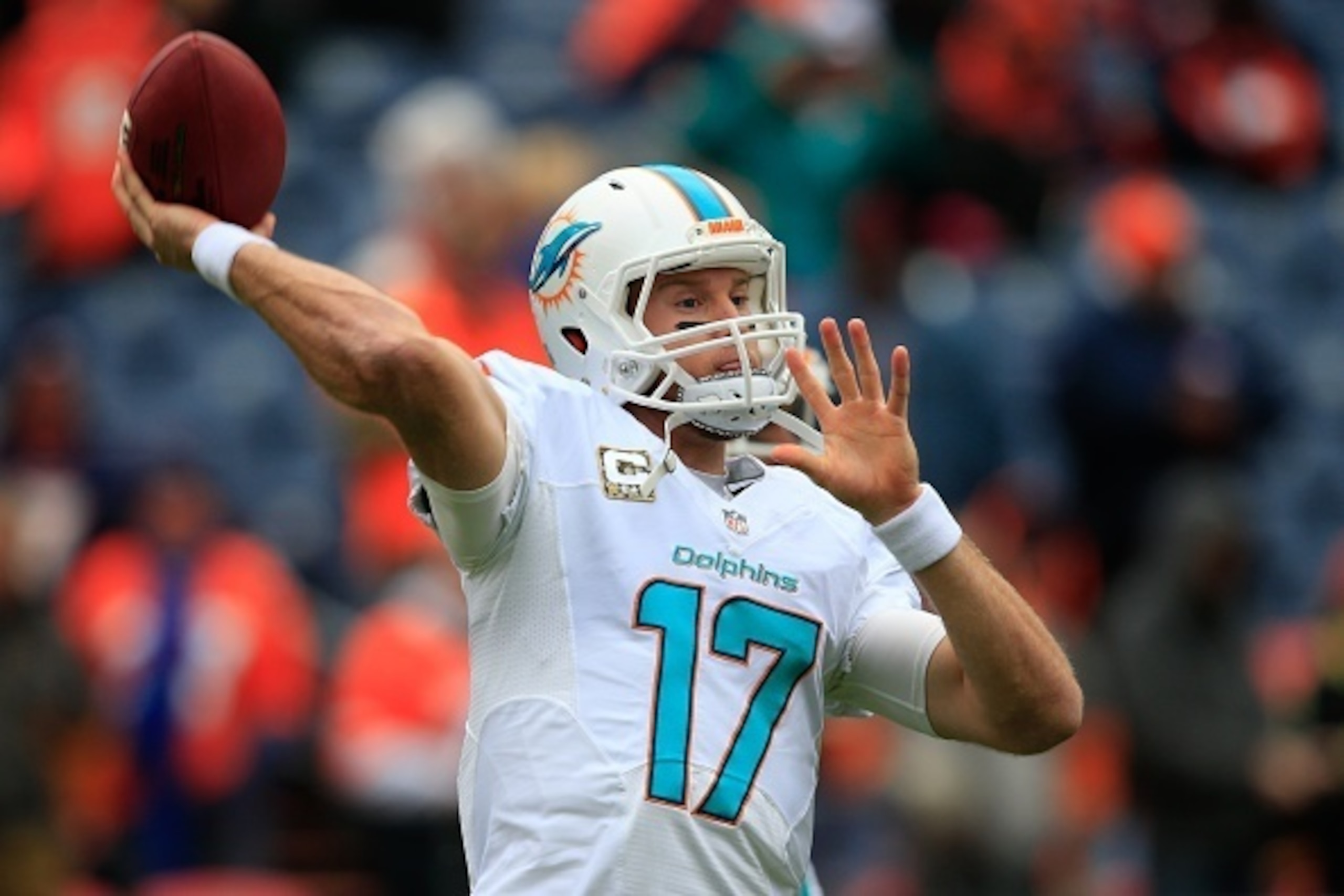DENVER, CO - NOVEMBER 23:  Quarterback Ryan Tannehill #17 of the Miami Dolphins throws as he warms up before a game against the Denver Broncos at Sports Authority Field at Mile High on November 23, 2014 in Denver, Colorado.  (Photo by Doug Pensinger/Getty