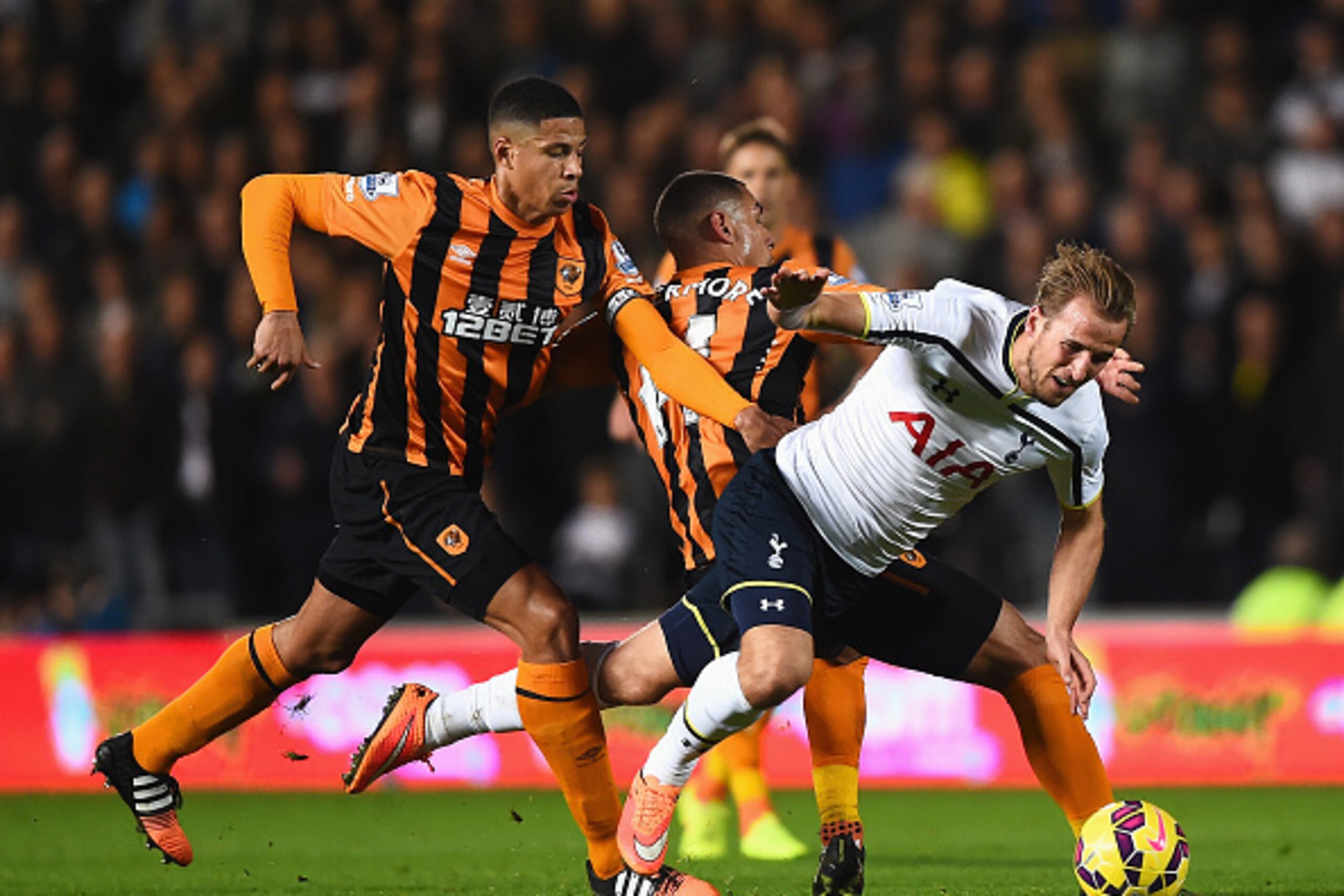 HULL, ENGLAND - NOVEMBER 23: Harry Kane of Tottenham Hotspur is challenged by Jake Livermore and Curtis Davies of Hull City during the Barclays Premier League match between Hull City and Tottenham Hotspur at KC Stadium on November 23, 2014 in Hull, Englan