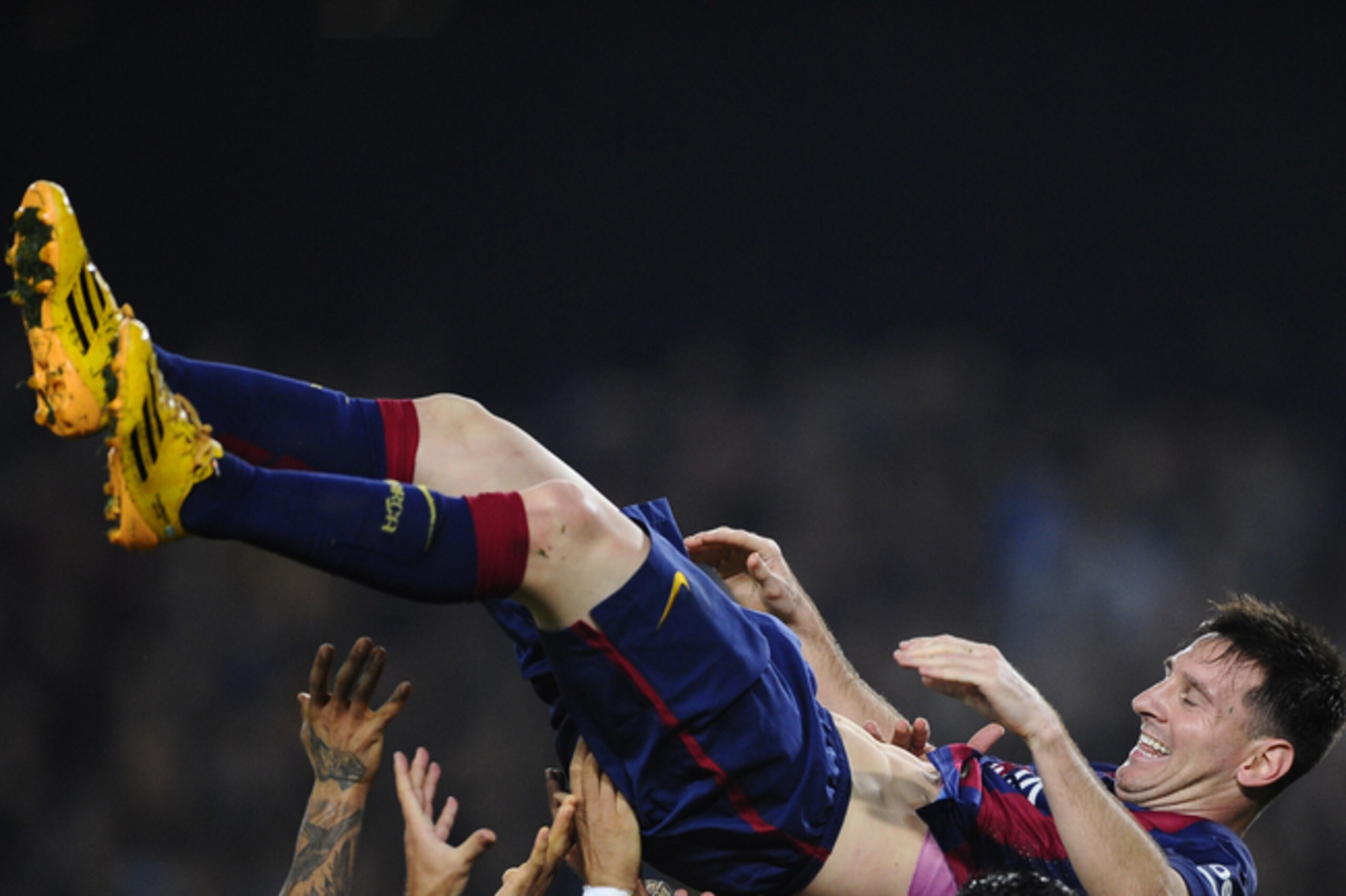 Hail to the king—Lionel Messi is lifted by team-mates following his La Liga hat-trick against Sevilla on Saturday